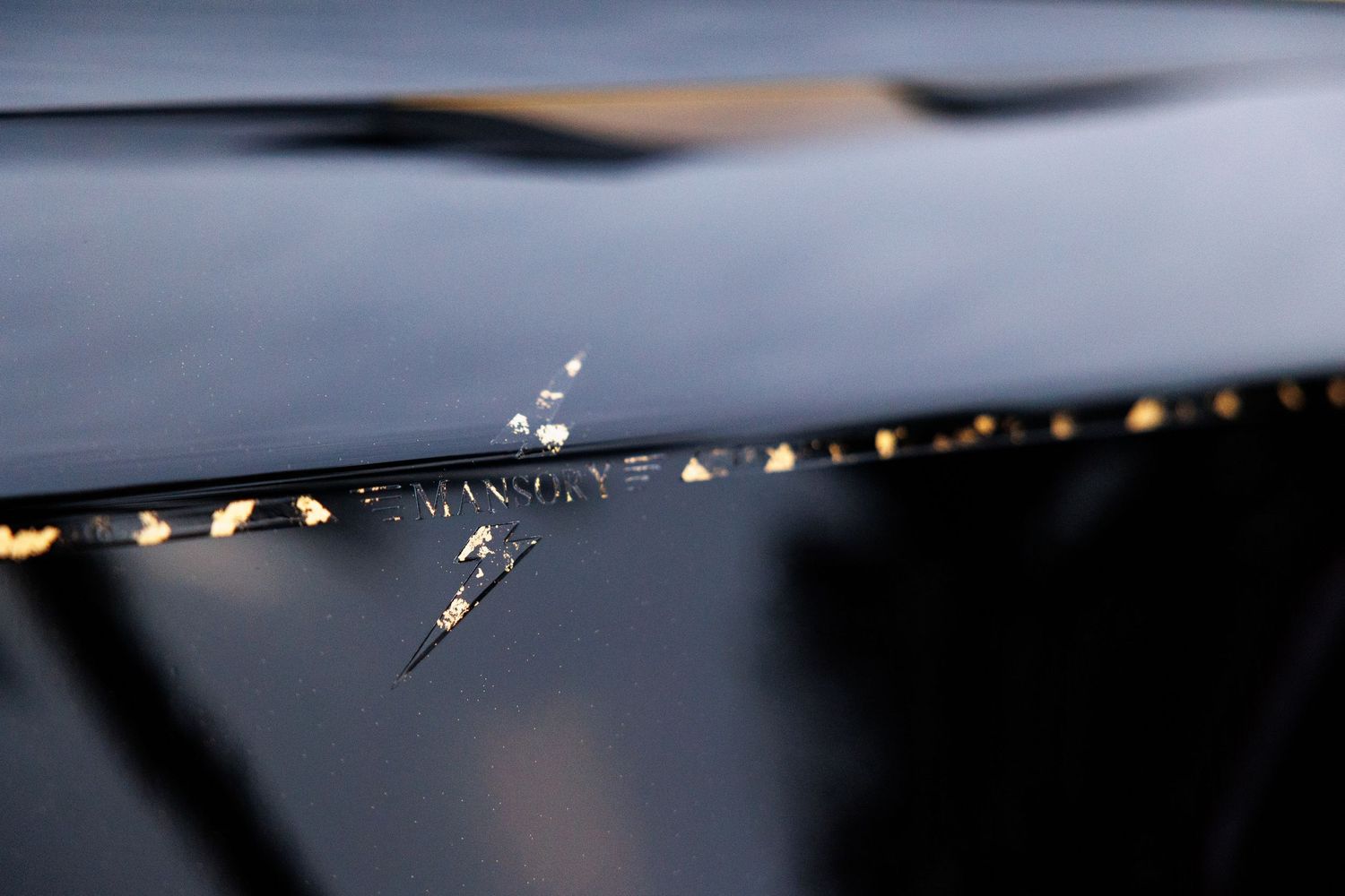 Macro shot of water droplets on a reflective dark surface.