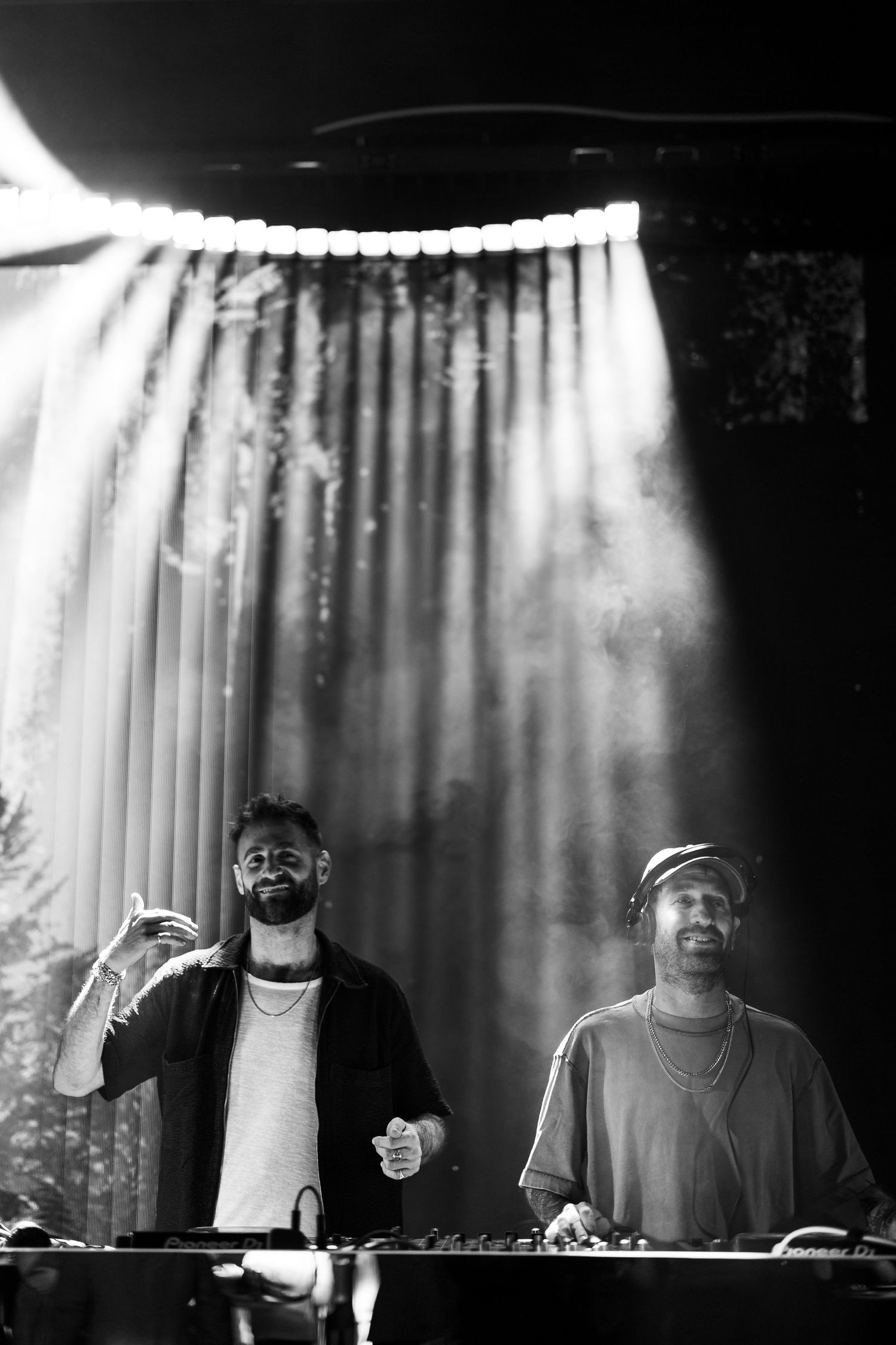 A series of black and white photographs showing silhouettes of performers against a backlit curtain on stage.