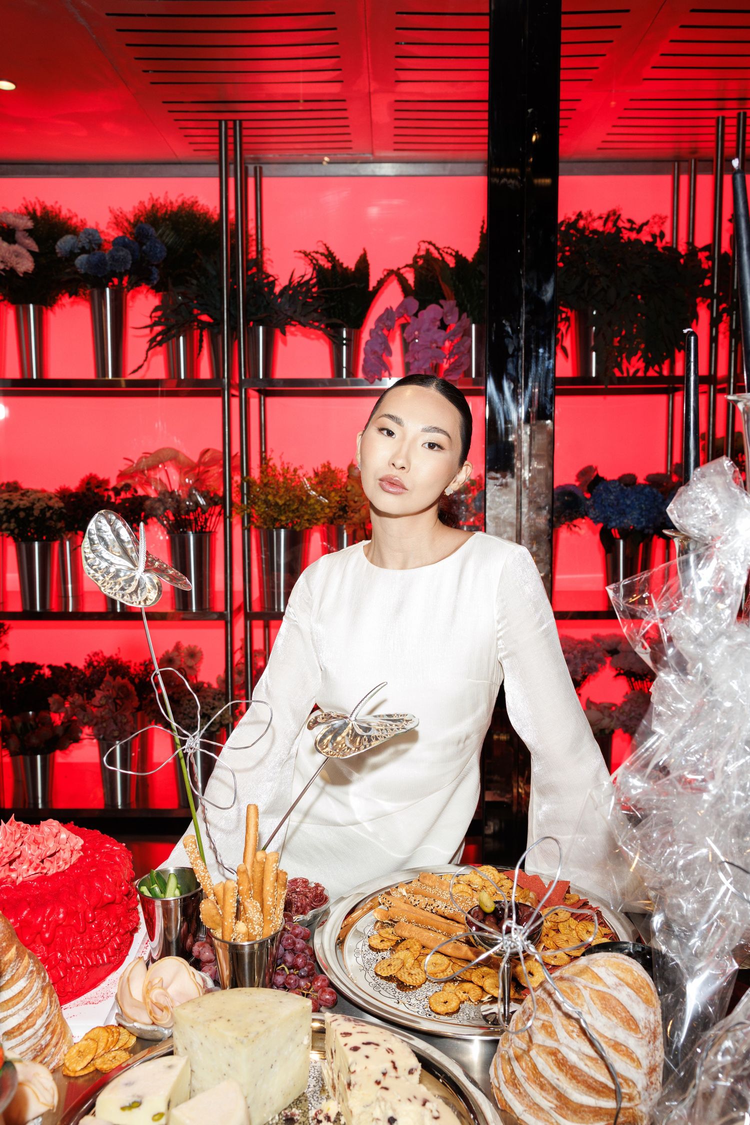 Table spread with wrapped food items and snacks under red ambient lighting.