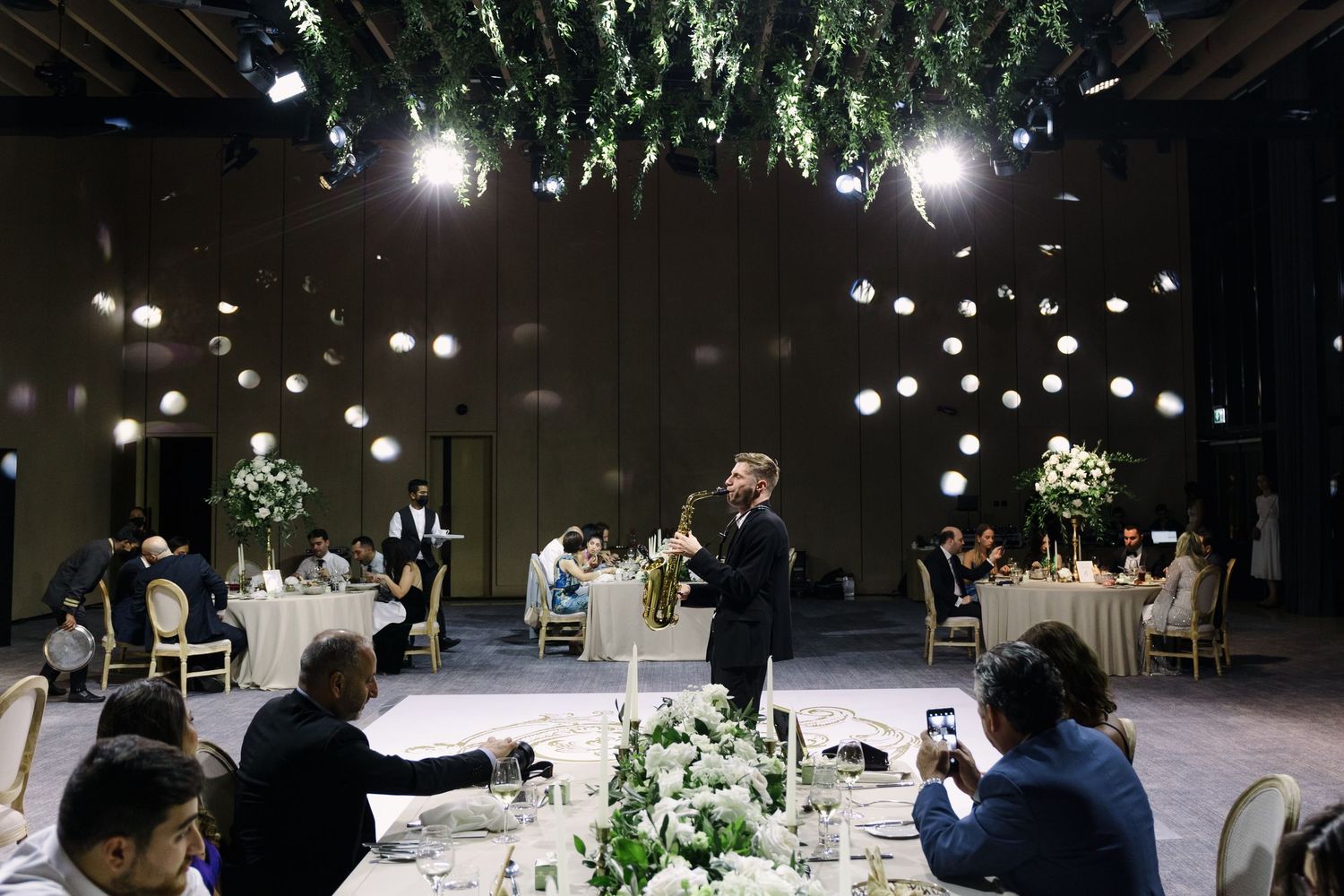Wedding reception venue with hanging lights and floral decorations creating an intimate atmosphere.