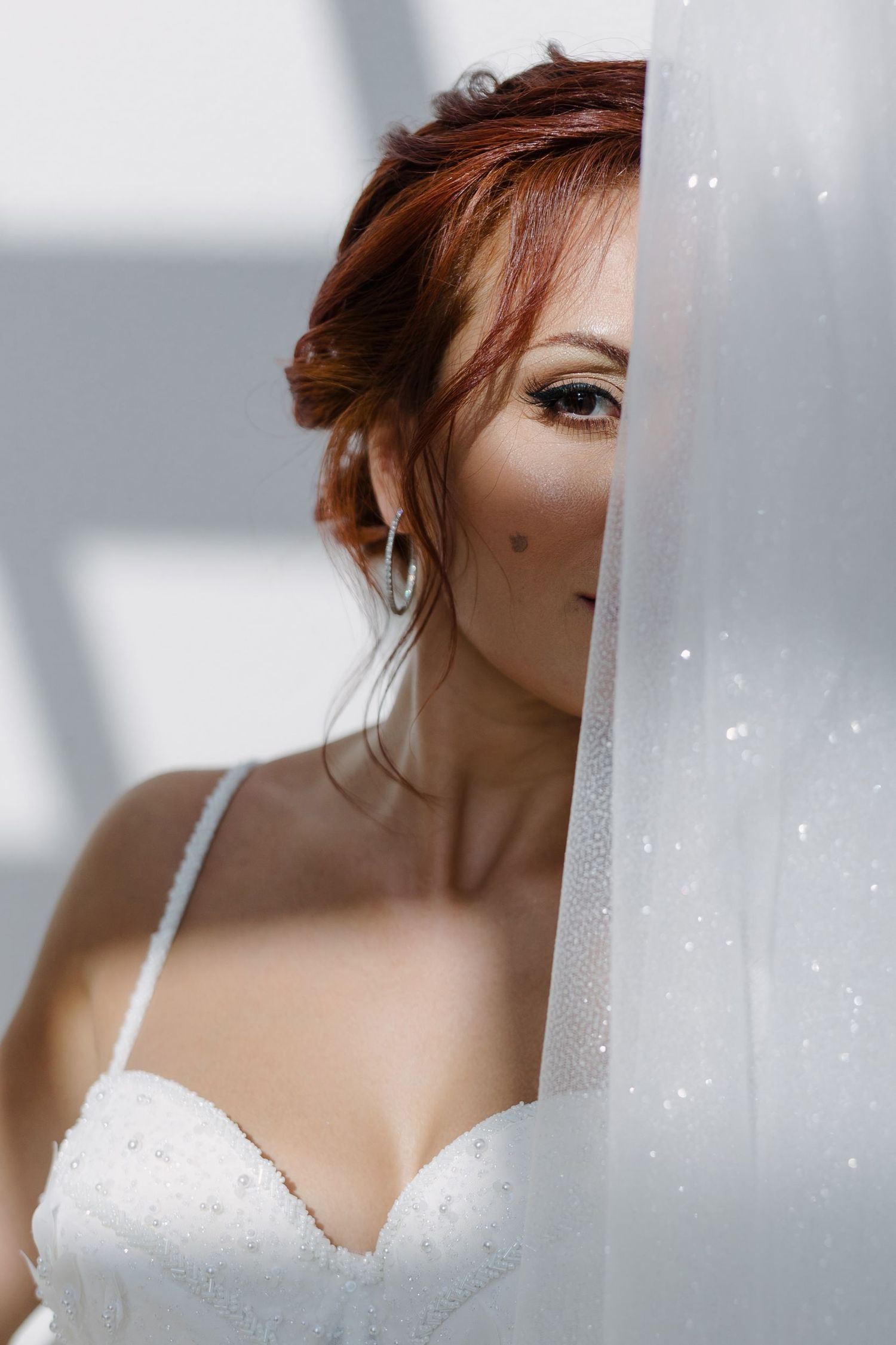 Close-up details of a white beaded wedding dress bodice with delicate straps.