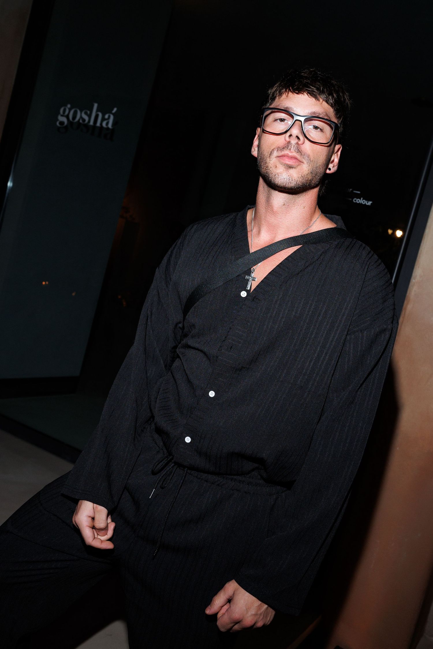 Person in black button-down shirt photographed in dark moody lighting.