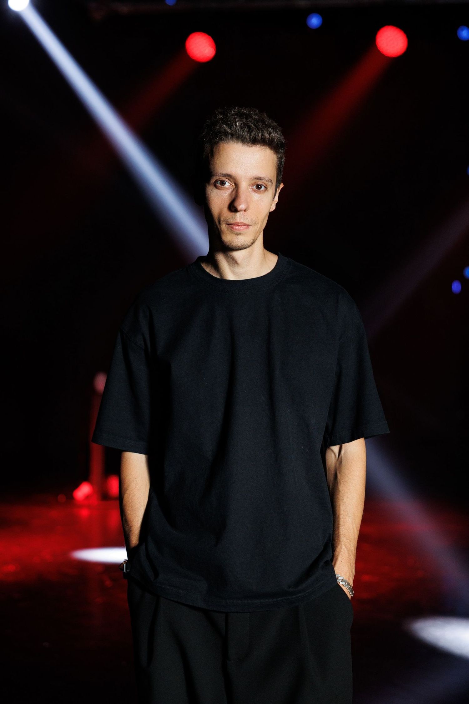 Dramatic stage lighting with red and blue spotlights creating an atmospheric performance space.