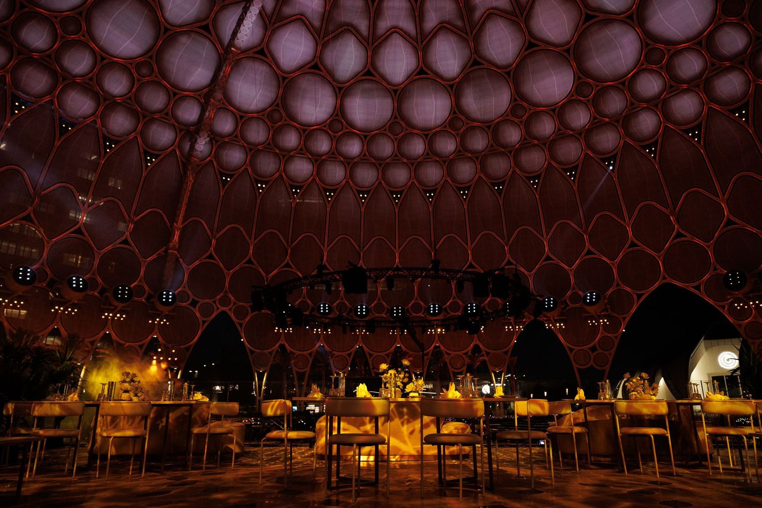 Ornate circular pattern ceiling design illuminated with warm lighting in an upscale venue.