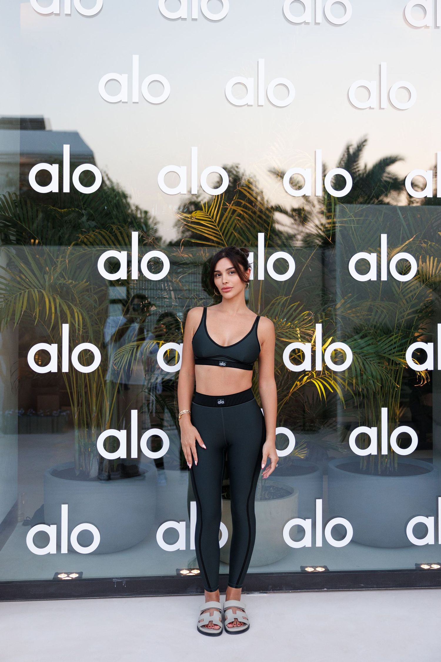 Alo branded storefront with repeated logo pattern on glass windows.