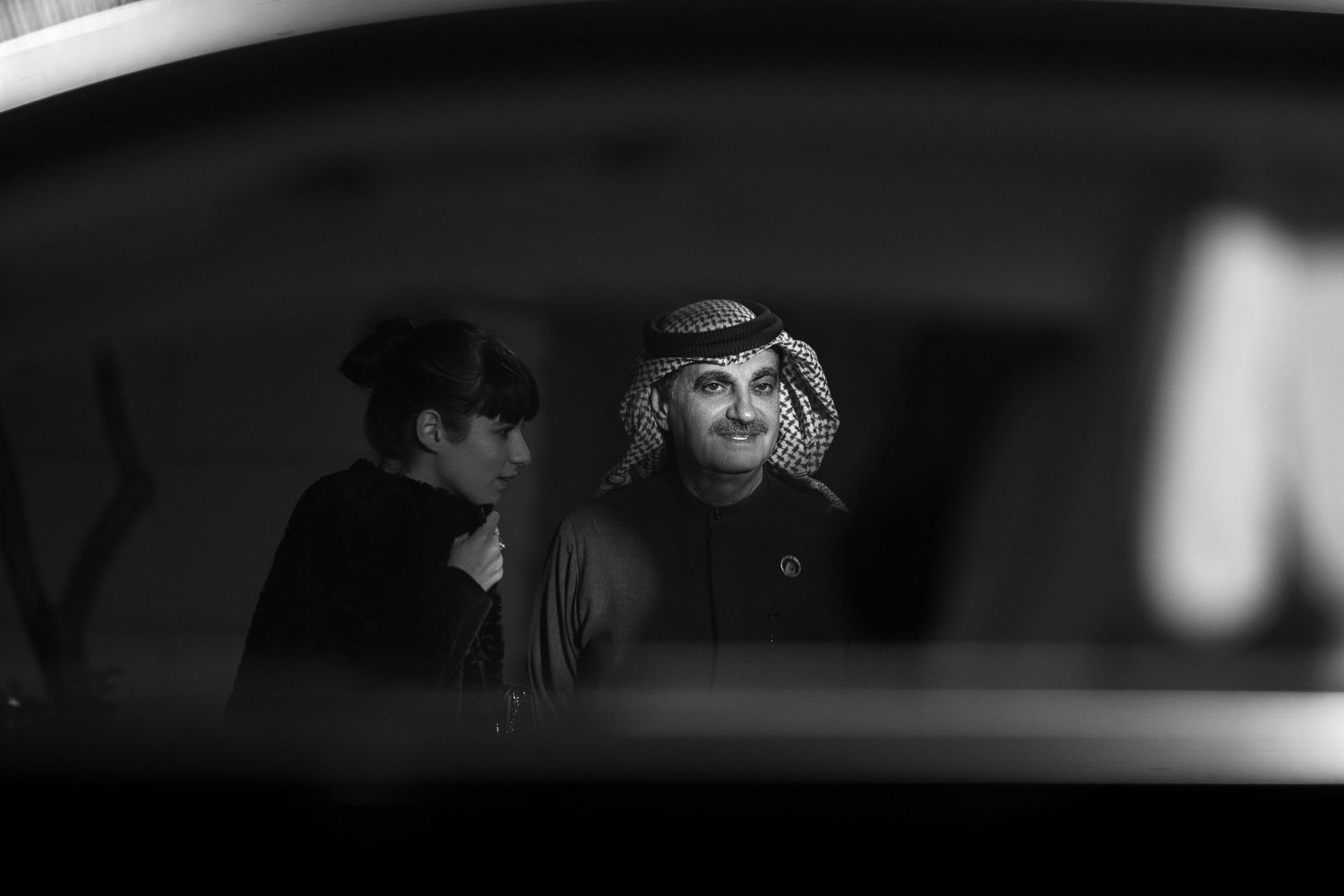 Dark silhouettes visible through car windows at night.