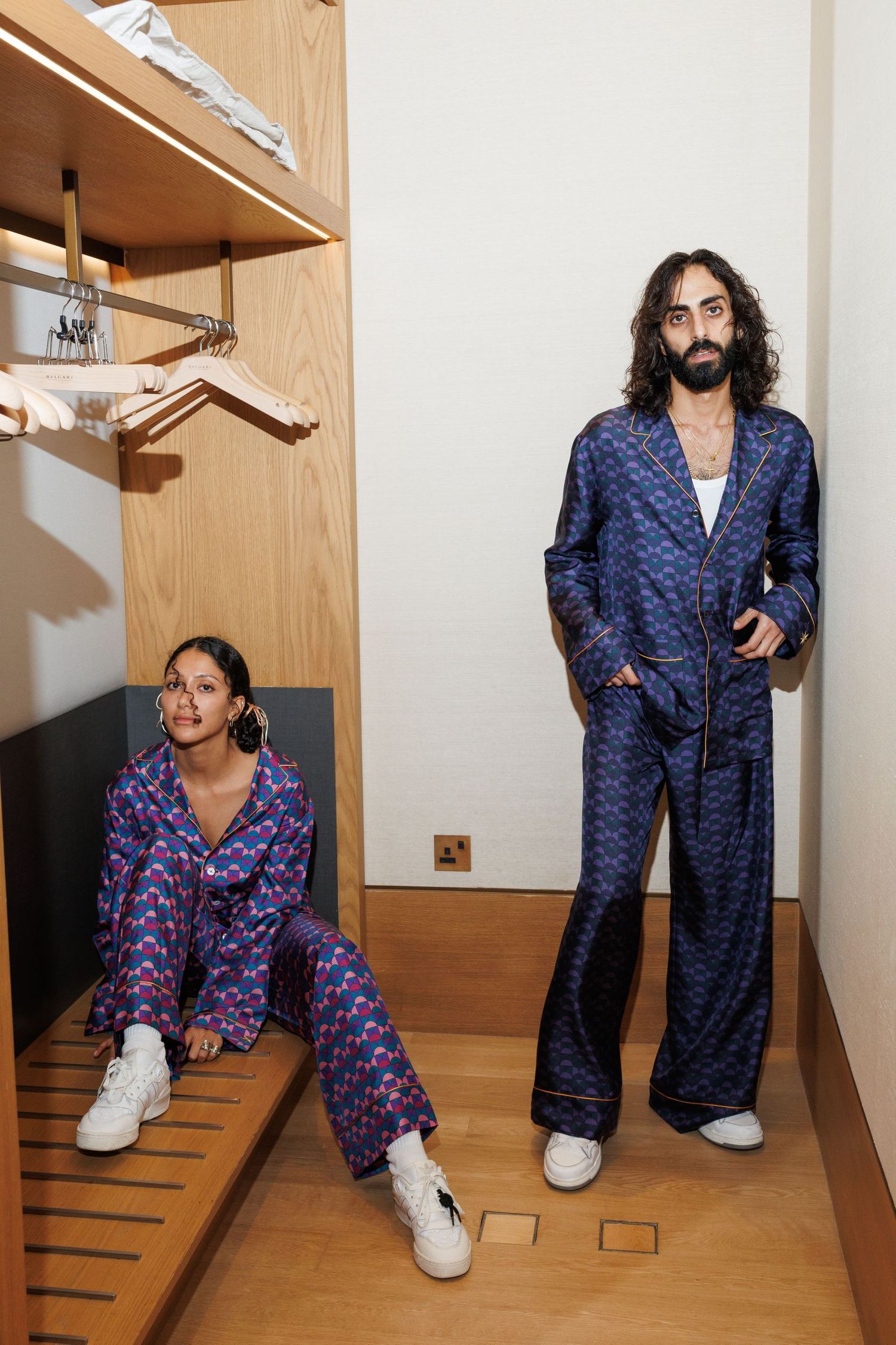 Person in blue patterned clothing poses in various positions near wooden cabinets.