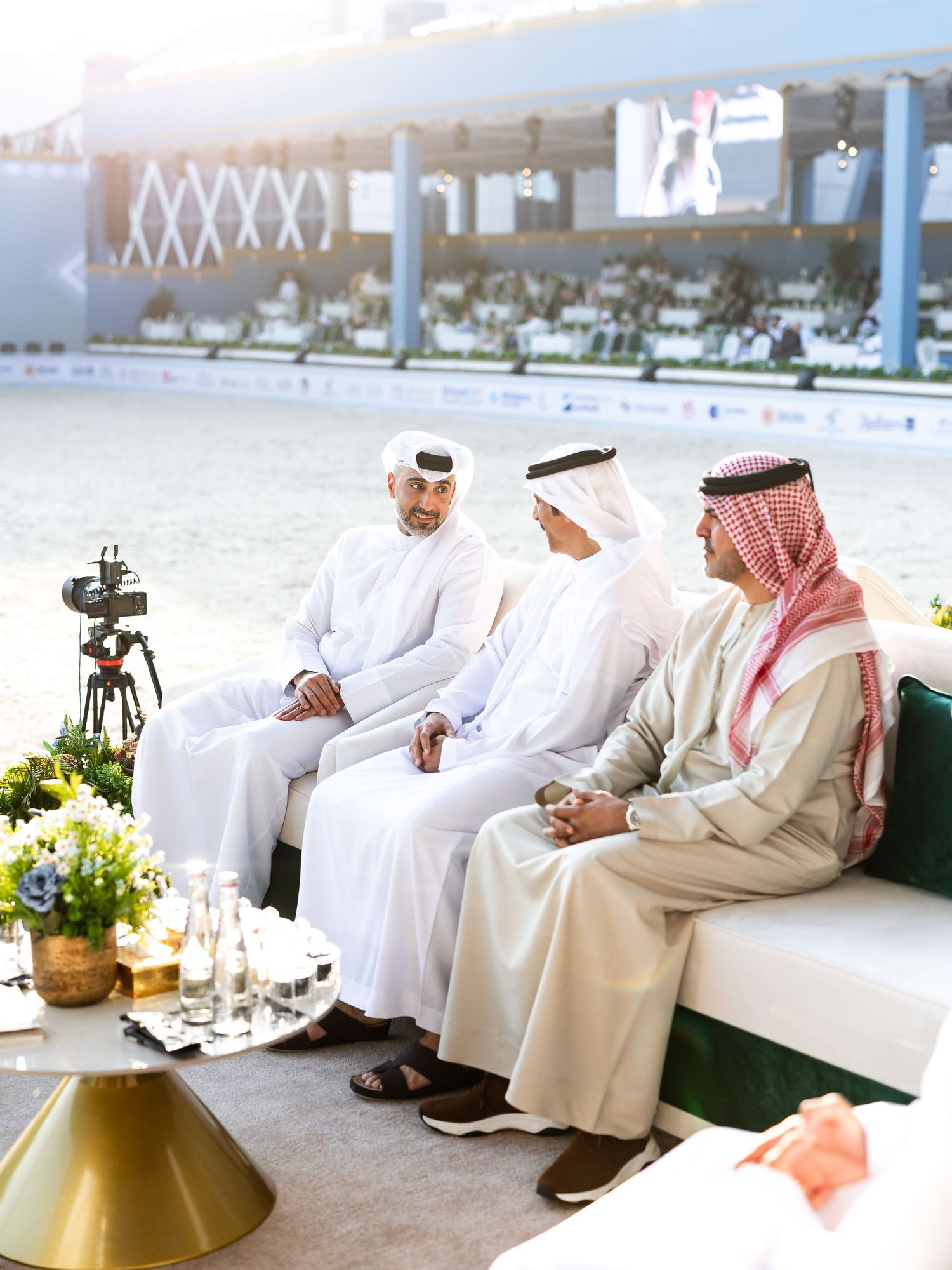 Business executives in traditional Middle Eastern attire having a meeting in a modern office setting.