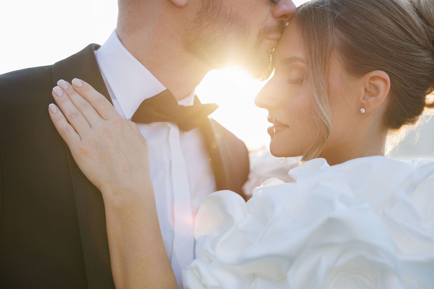 Romantic sunlit wedding photography session with soft natural backlighting.