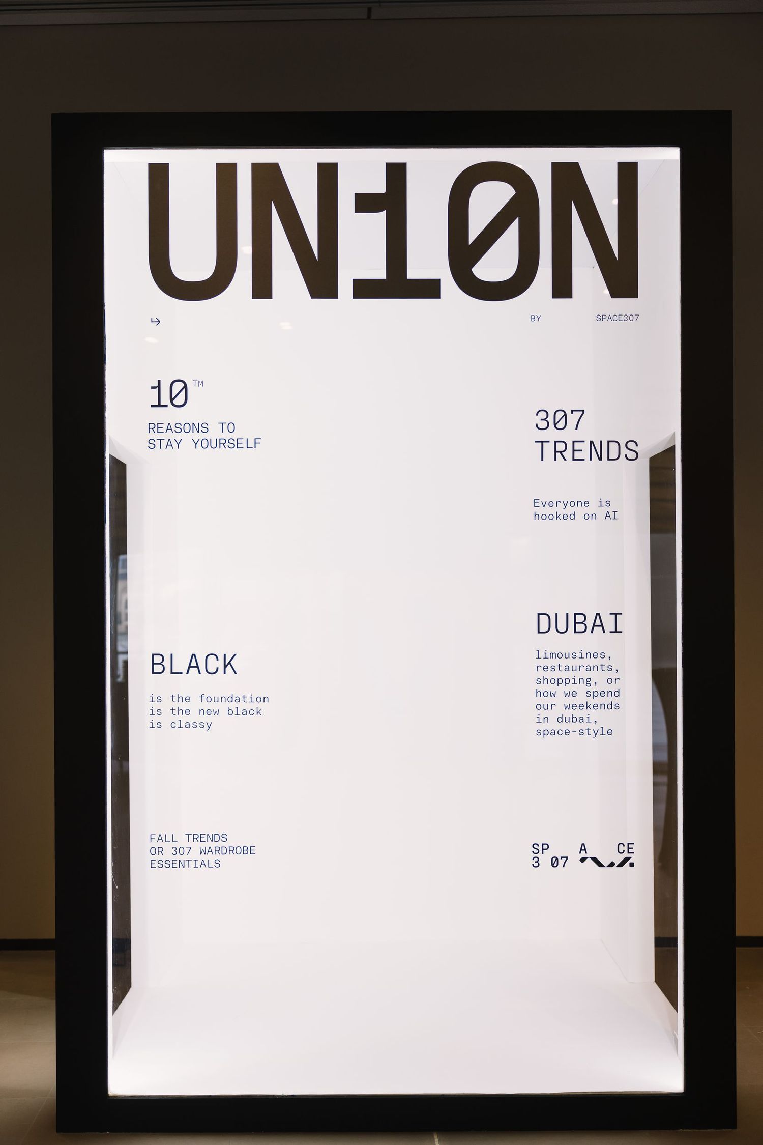 White exhibition wall displays with minimalist typography showing UNION and DUBAI text.