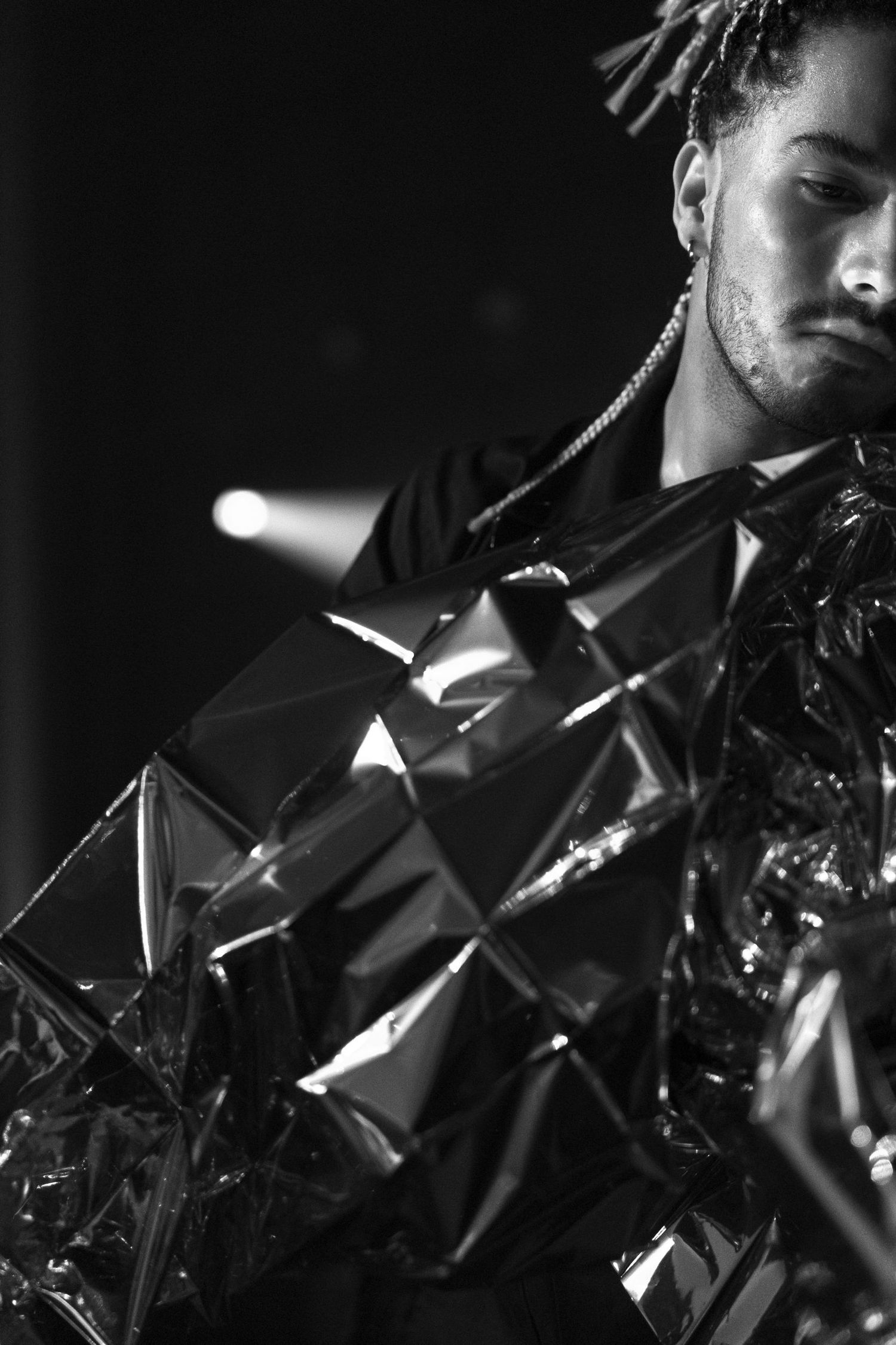 Artistic black and white photograph of reflective metallic surfaces creating angular patterns.