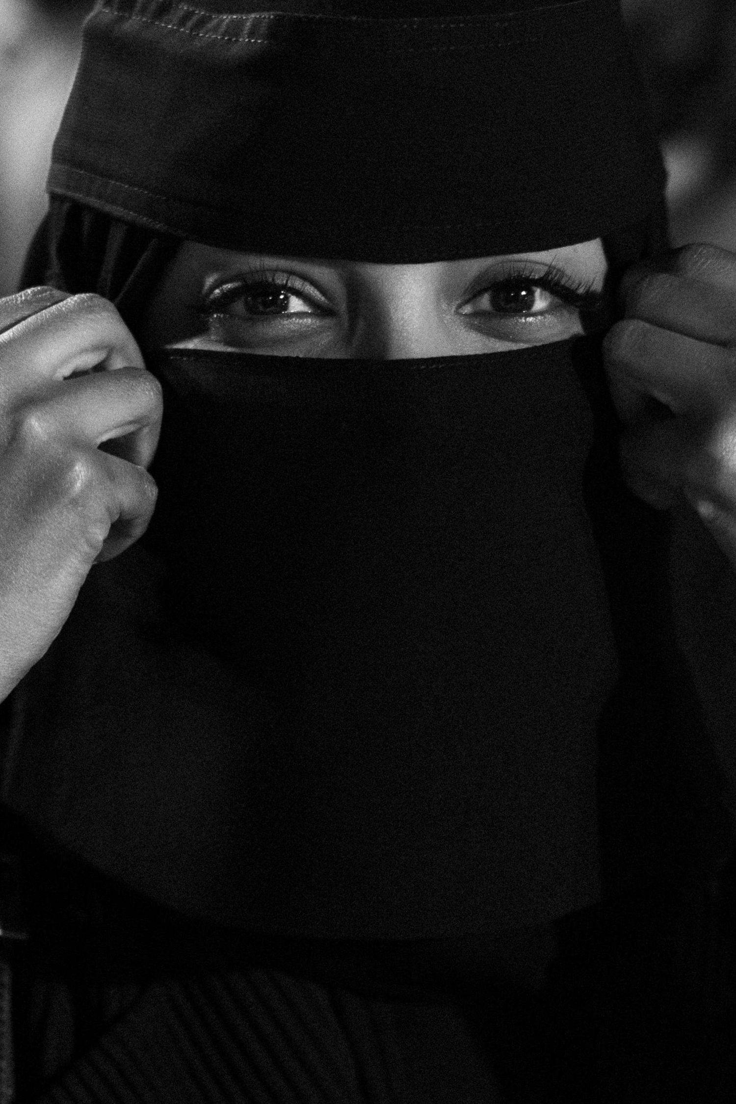 Close-up shots of eyes through dark fabric in dramatic lighting.