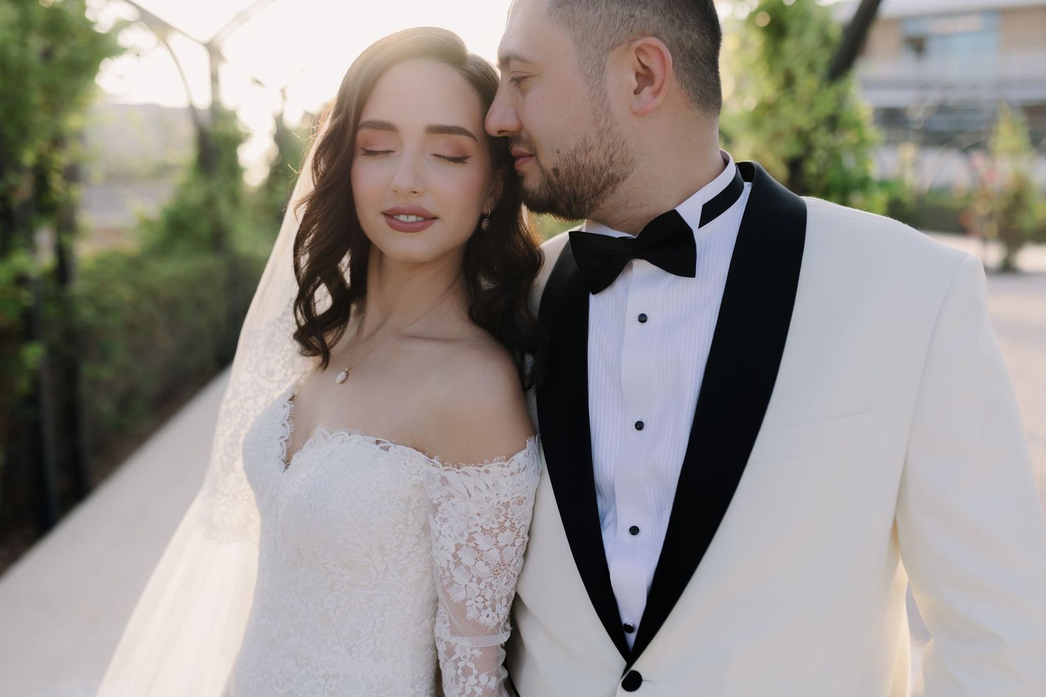 Romantic wedding portrait in an outdoor garden setting at golden hour.