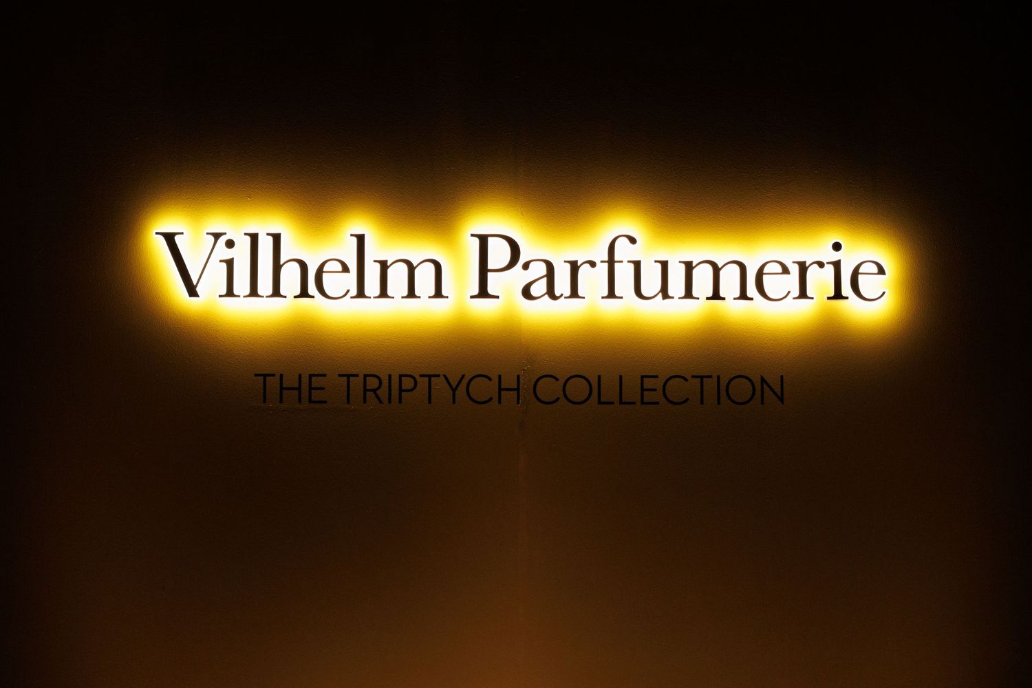 Brightly lit 'Vilhelm Parfumerie' storefront signage at night.