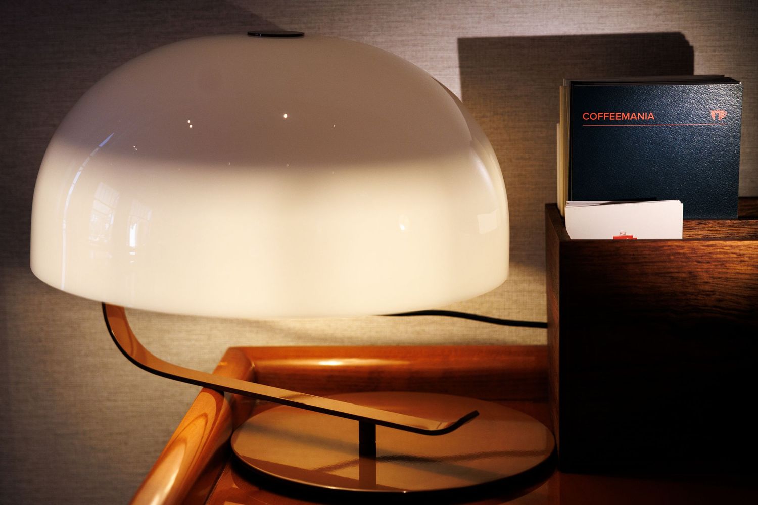 Modern pendant lamp with white shade creating ambient lighting in restaurant setting.