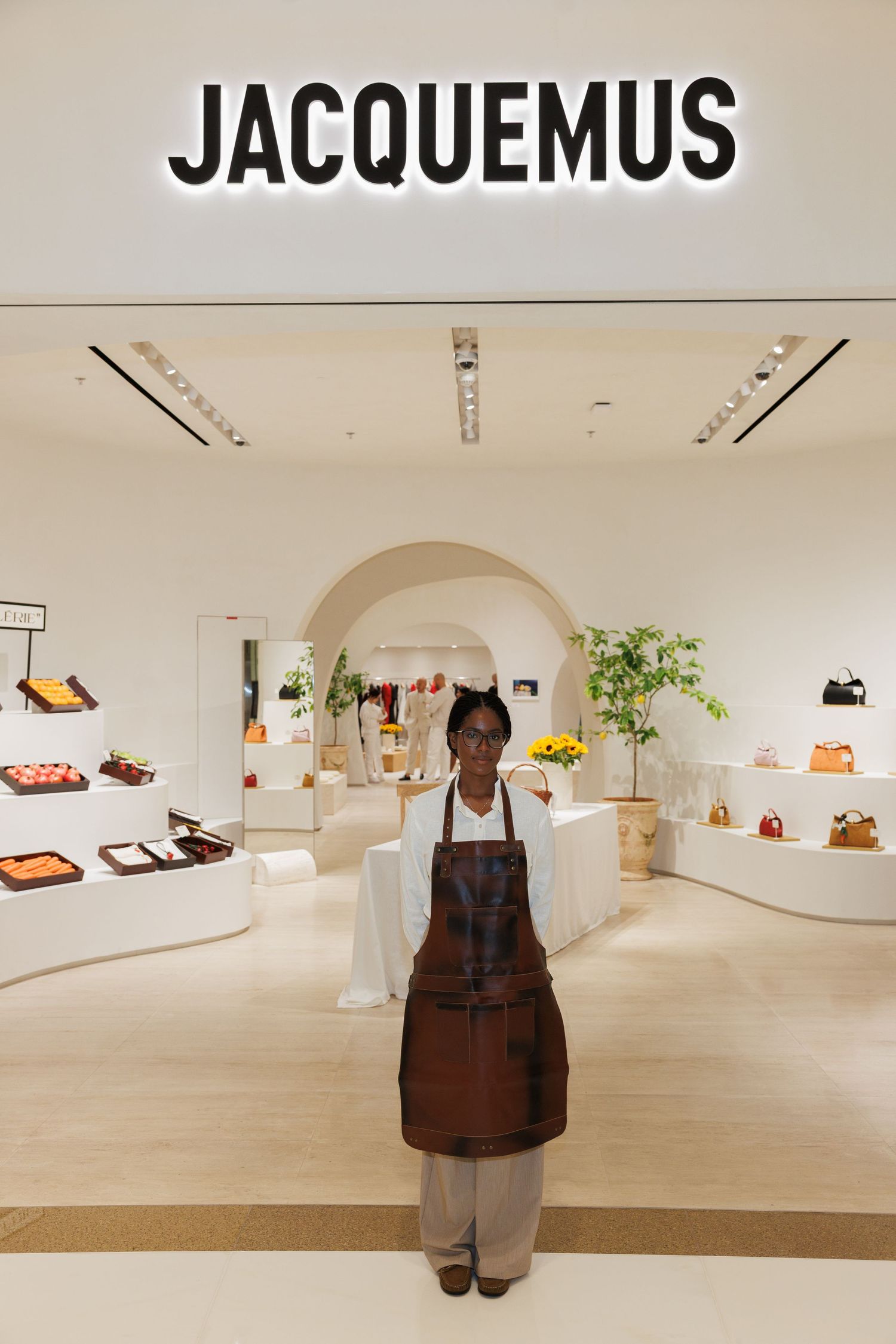 Interior view of minimalist Jacquemus boutique with arched entryway.