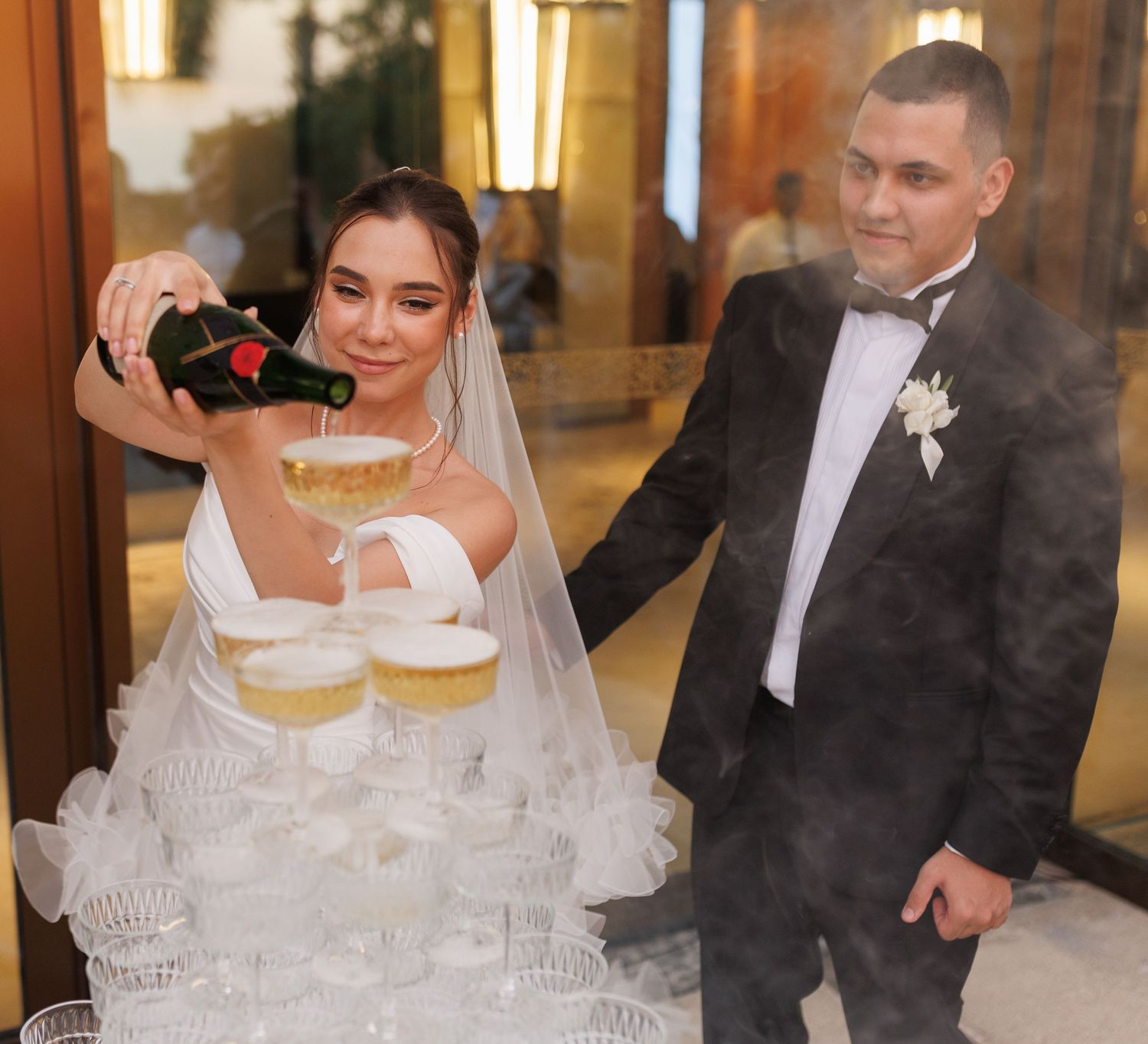 Champagne tower being set up at an elegant wedding reception.
