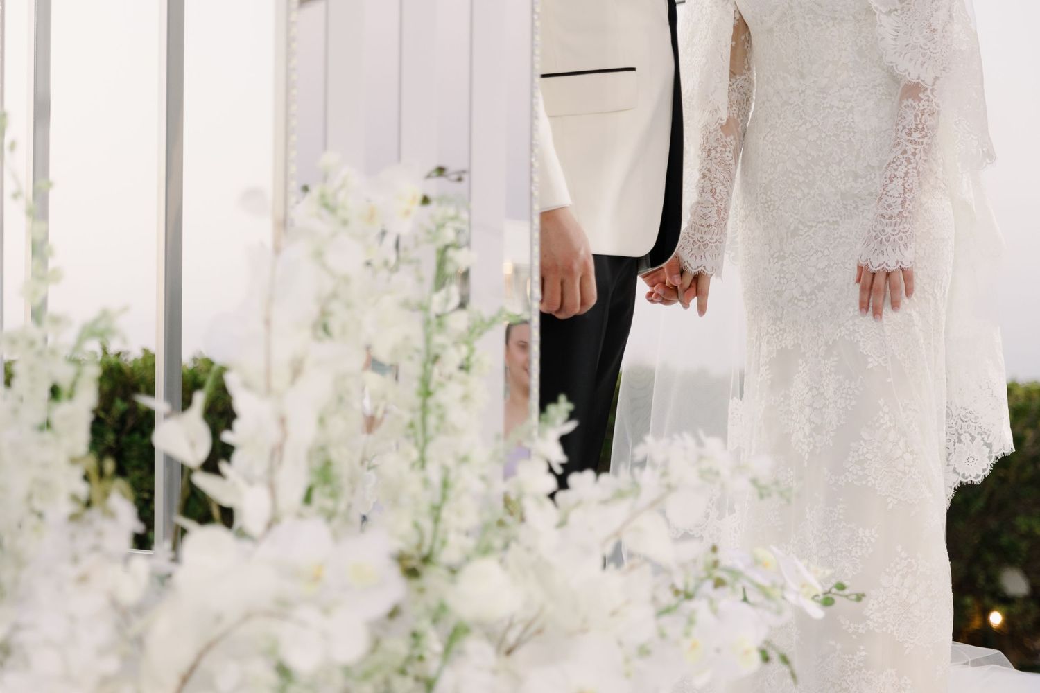 Close-up details of wedding attire and decor in white tones.