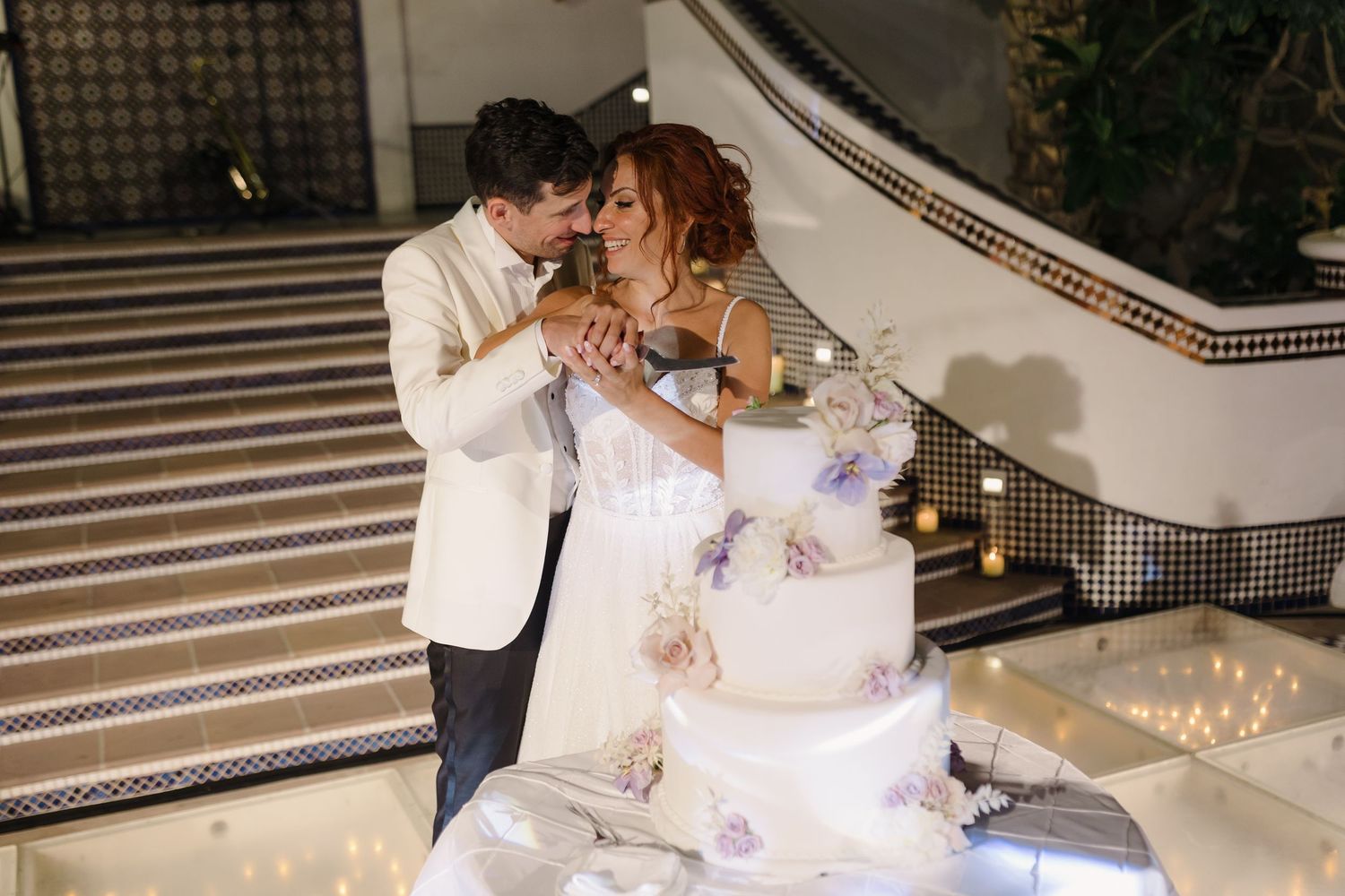 Wedding guests enjoy a relaxed moment on outdoor lounge furniture during evening reception.