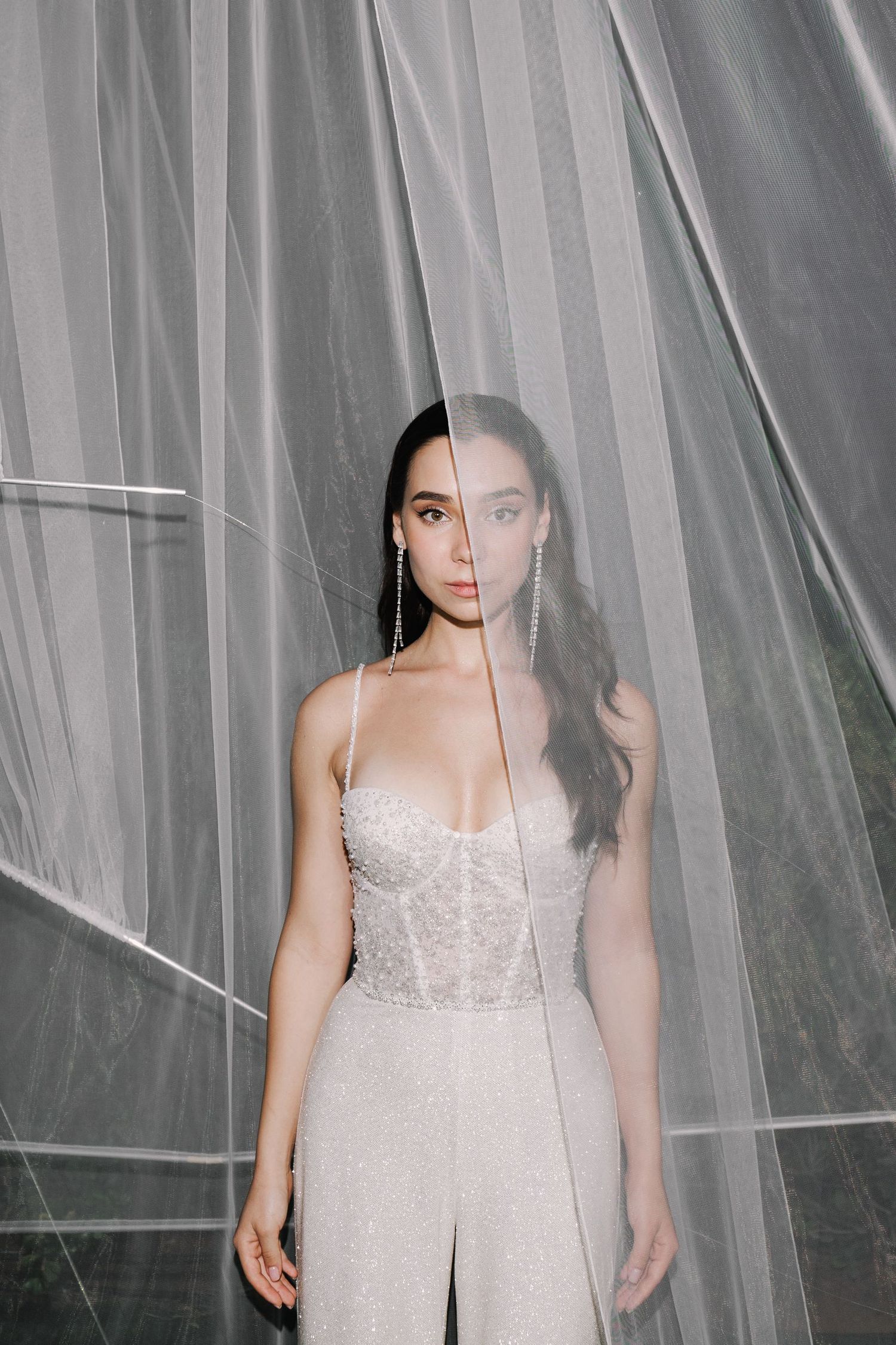 Bridal portrait through sheer white tulle creating a dreamy, romantic atmosphere.