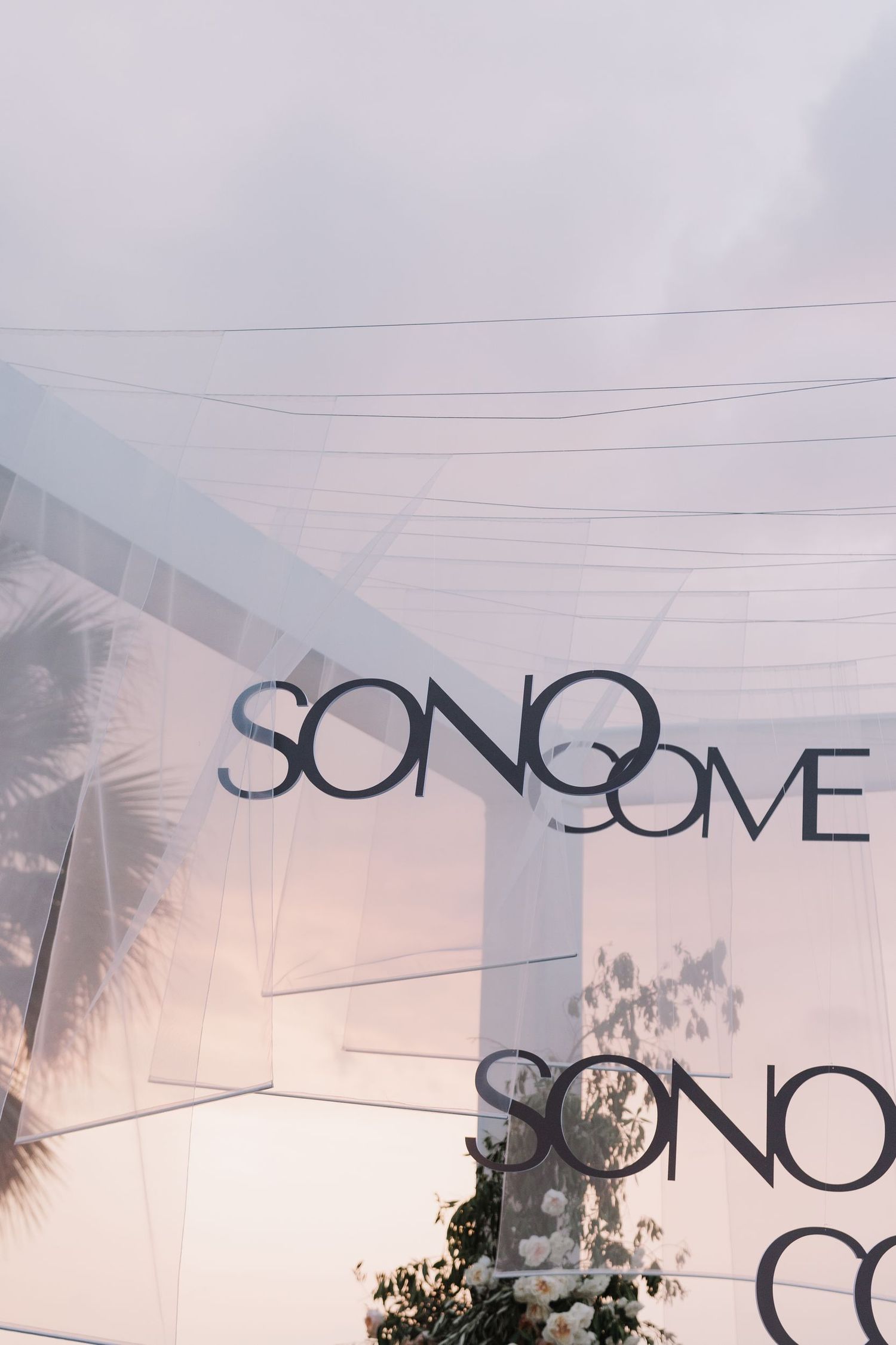 White tent structure with 'SONO' text visible against a sunset sky.