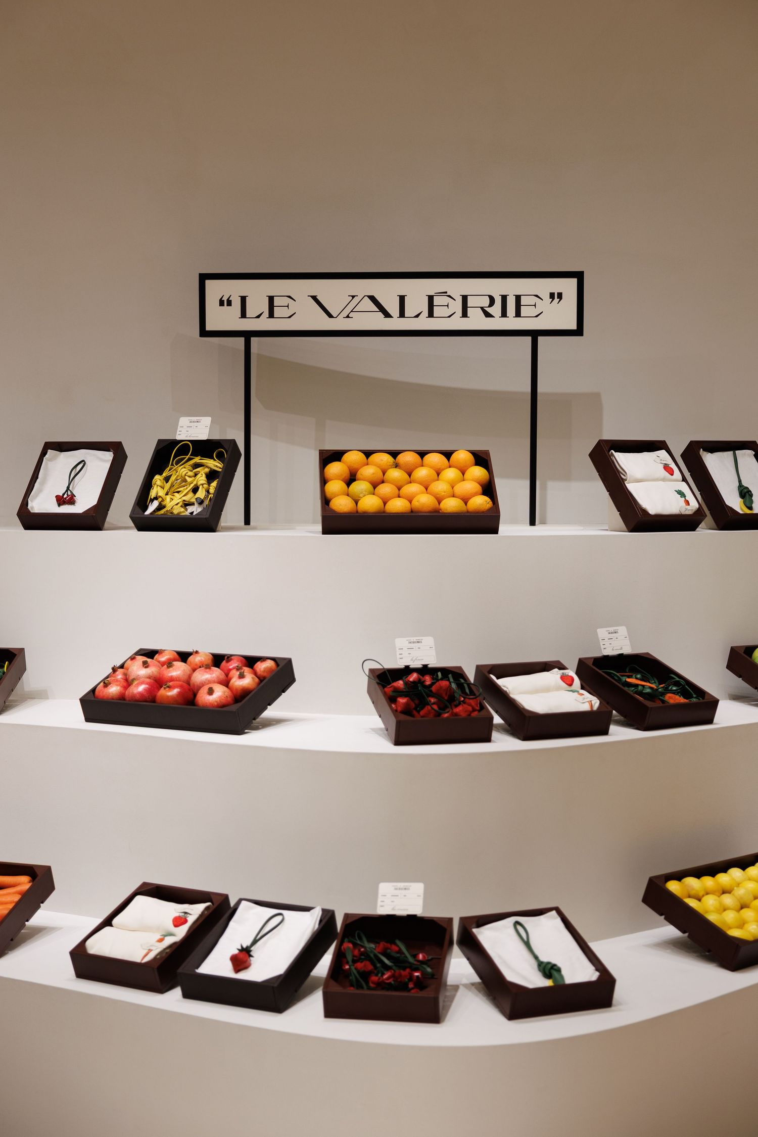 Le Valerie display shelf showcasing colorful fruits and products in dark trays.