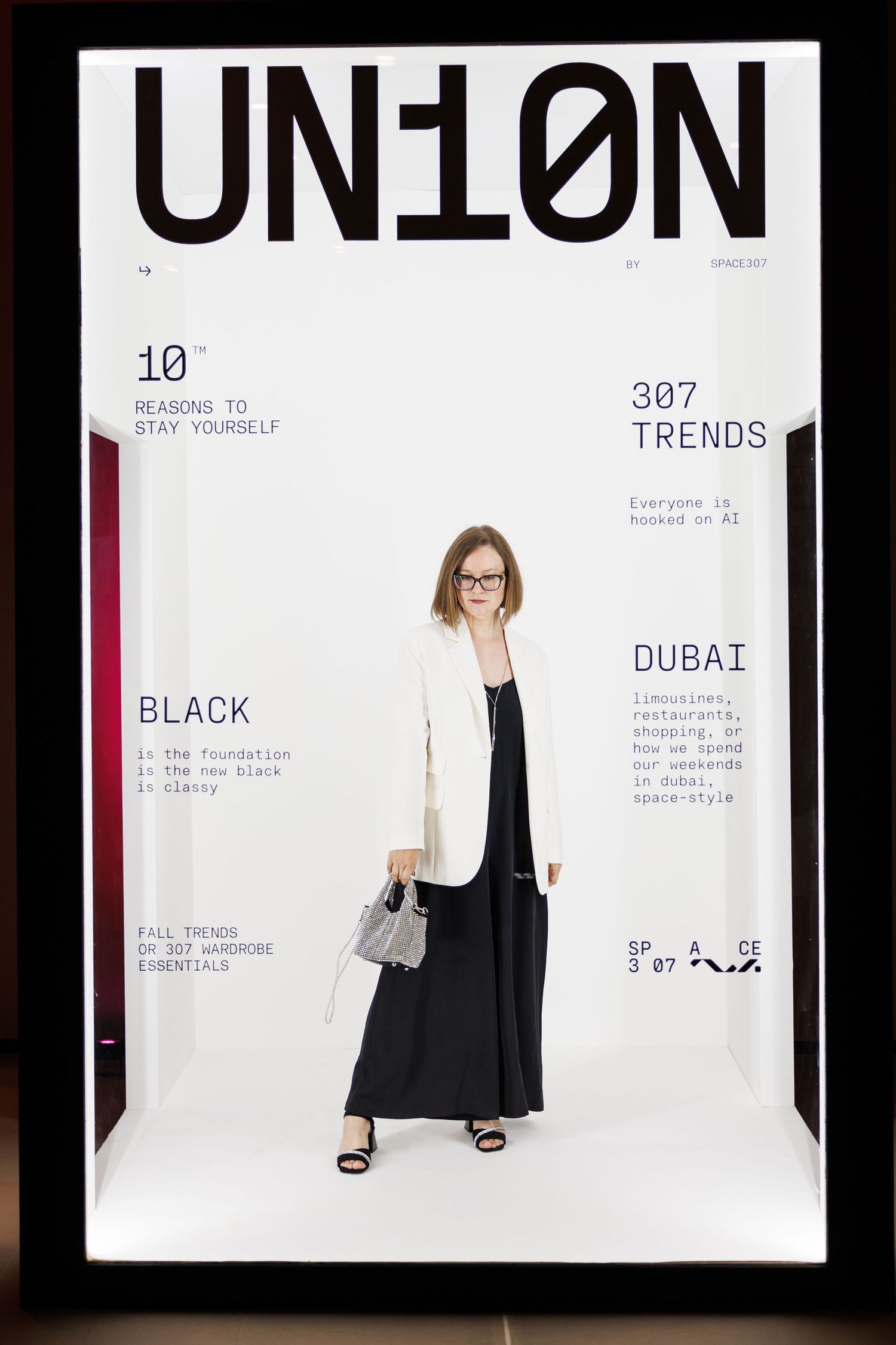 Fashion model poses in black outfit against white backdrop with text overlays showing style trends.