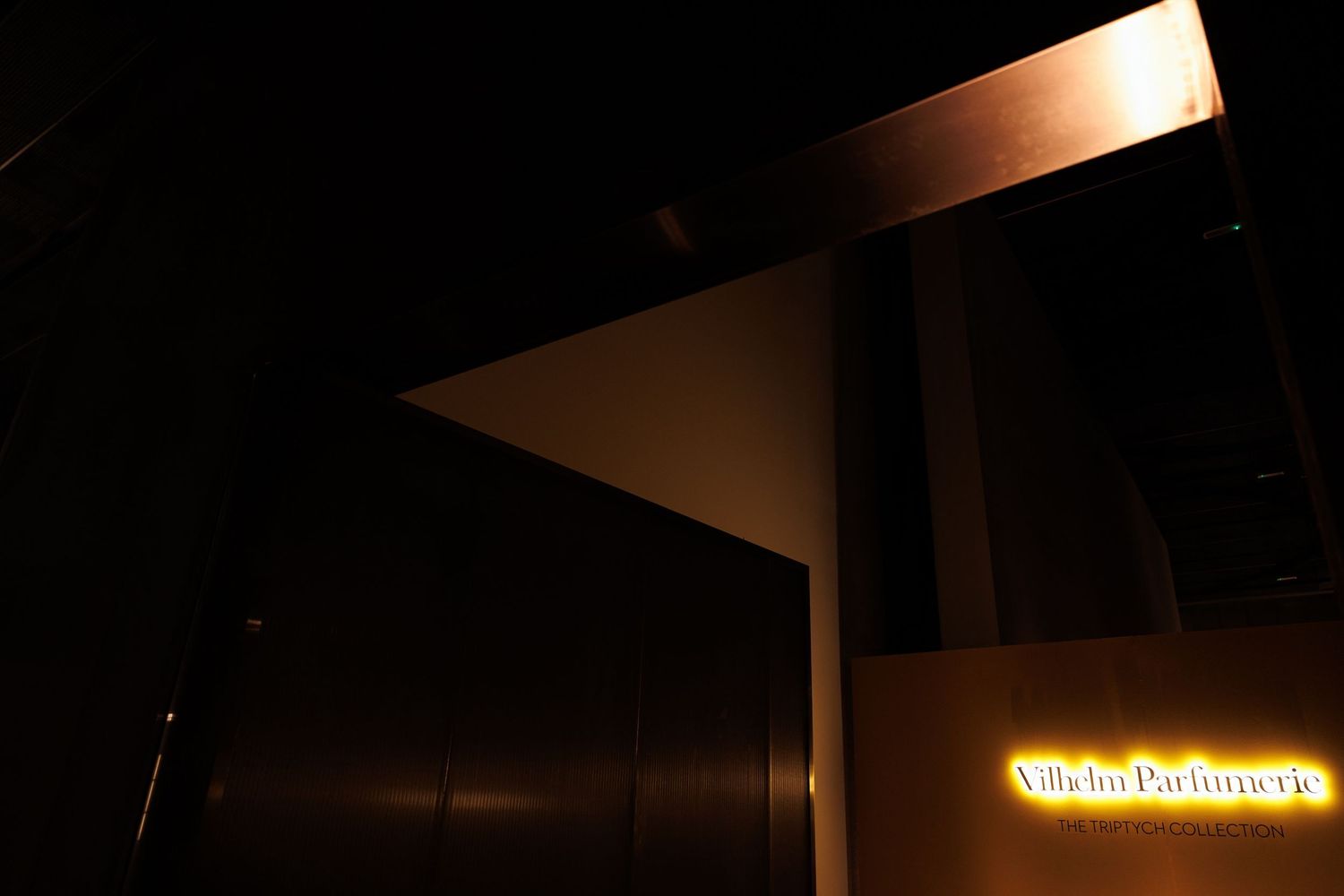 Dark hallway with glowing yellow sign visible at the far end.