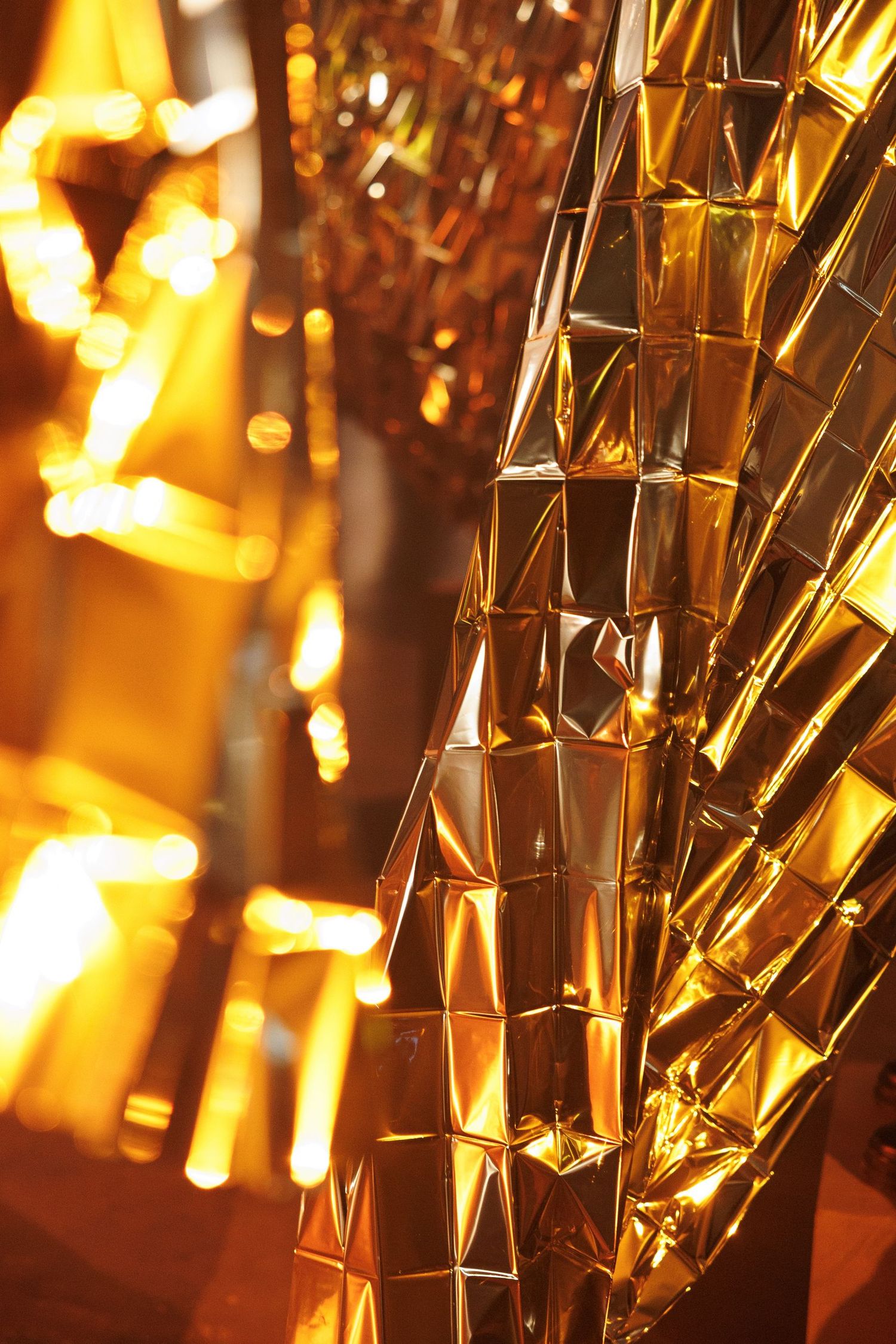 Close-up of metallic gold decorative elements illuminated with warm glowing lights.