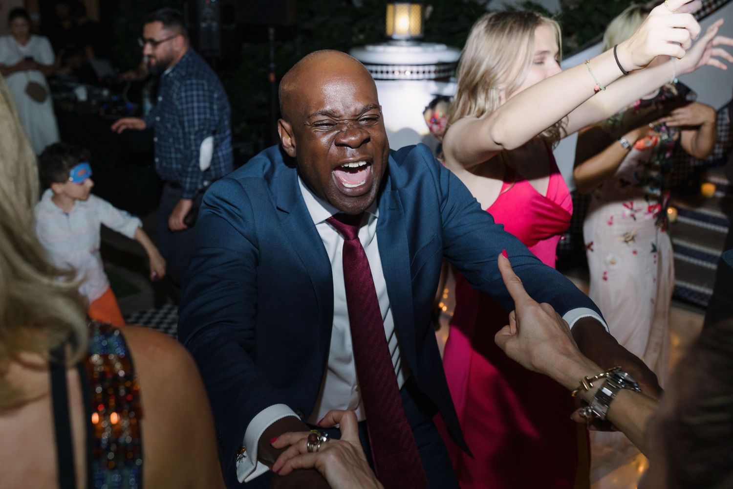Wedding reception dance floor filled with guests celebrating and dancing together.