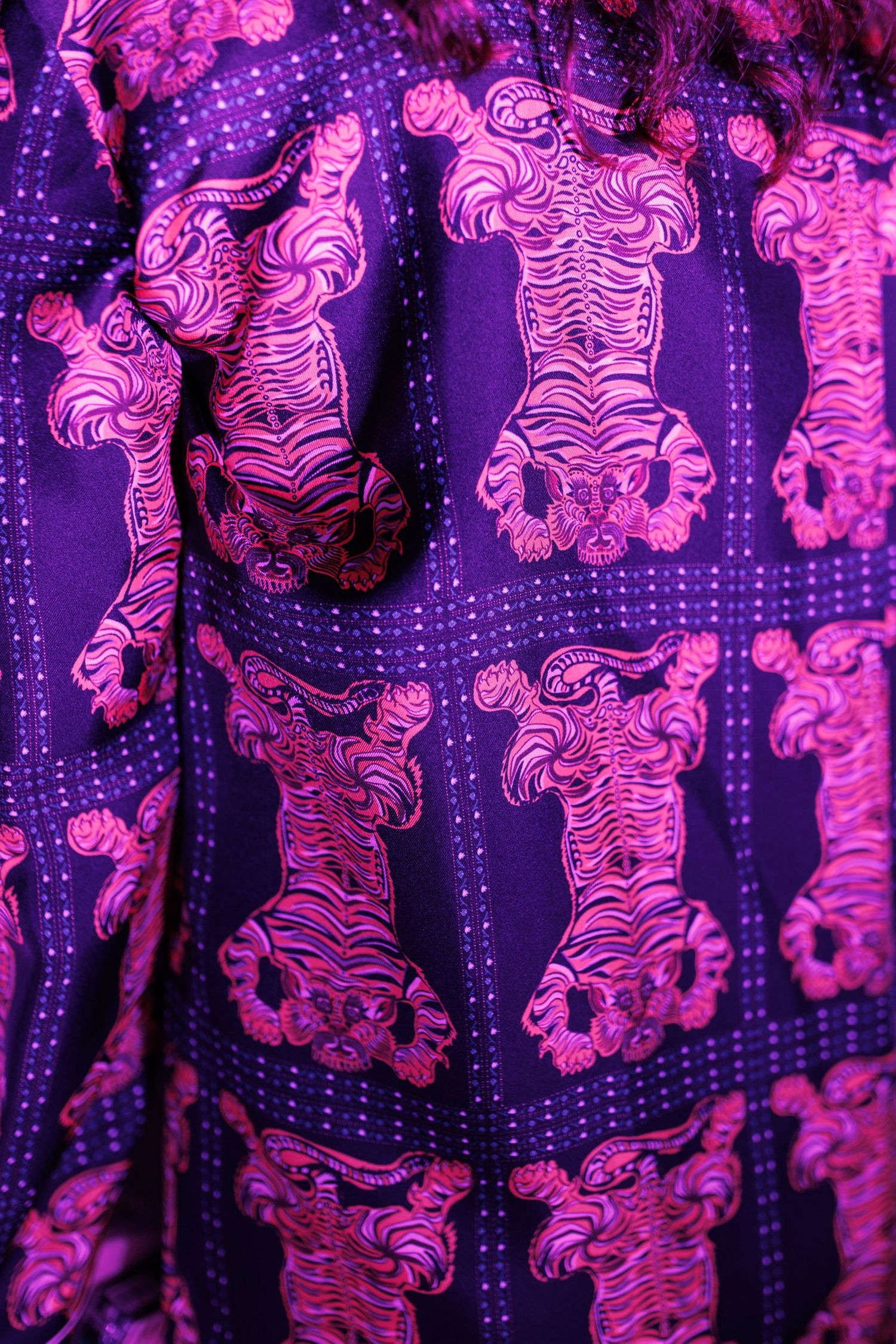 Close-up of vibrant pink and purple tiger print fabric pattern.