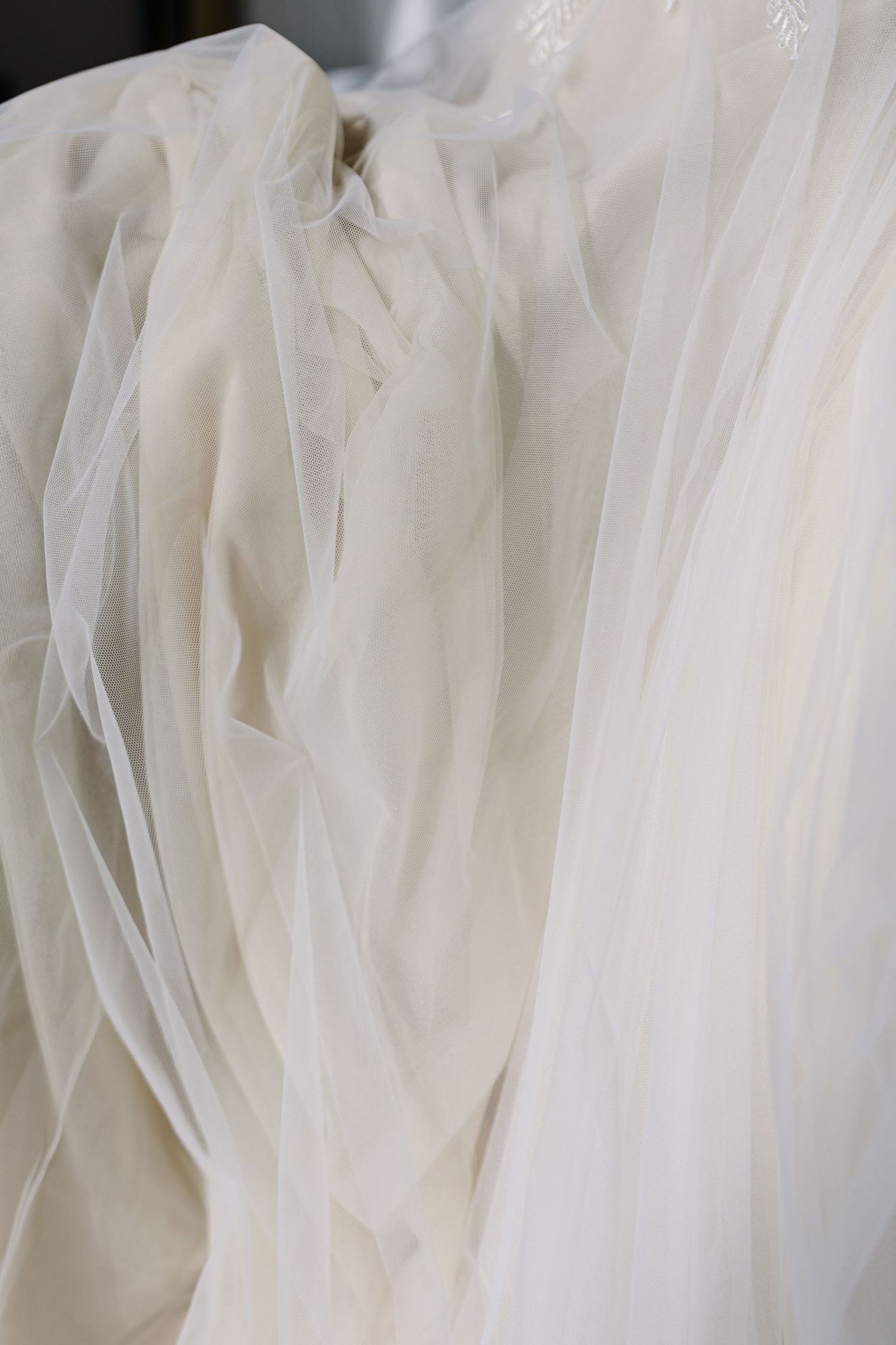 Close-up detail of white tulle fabric layers creating soft textural pattern.