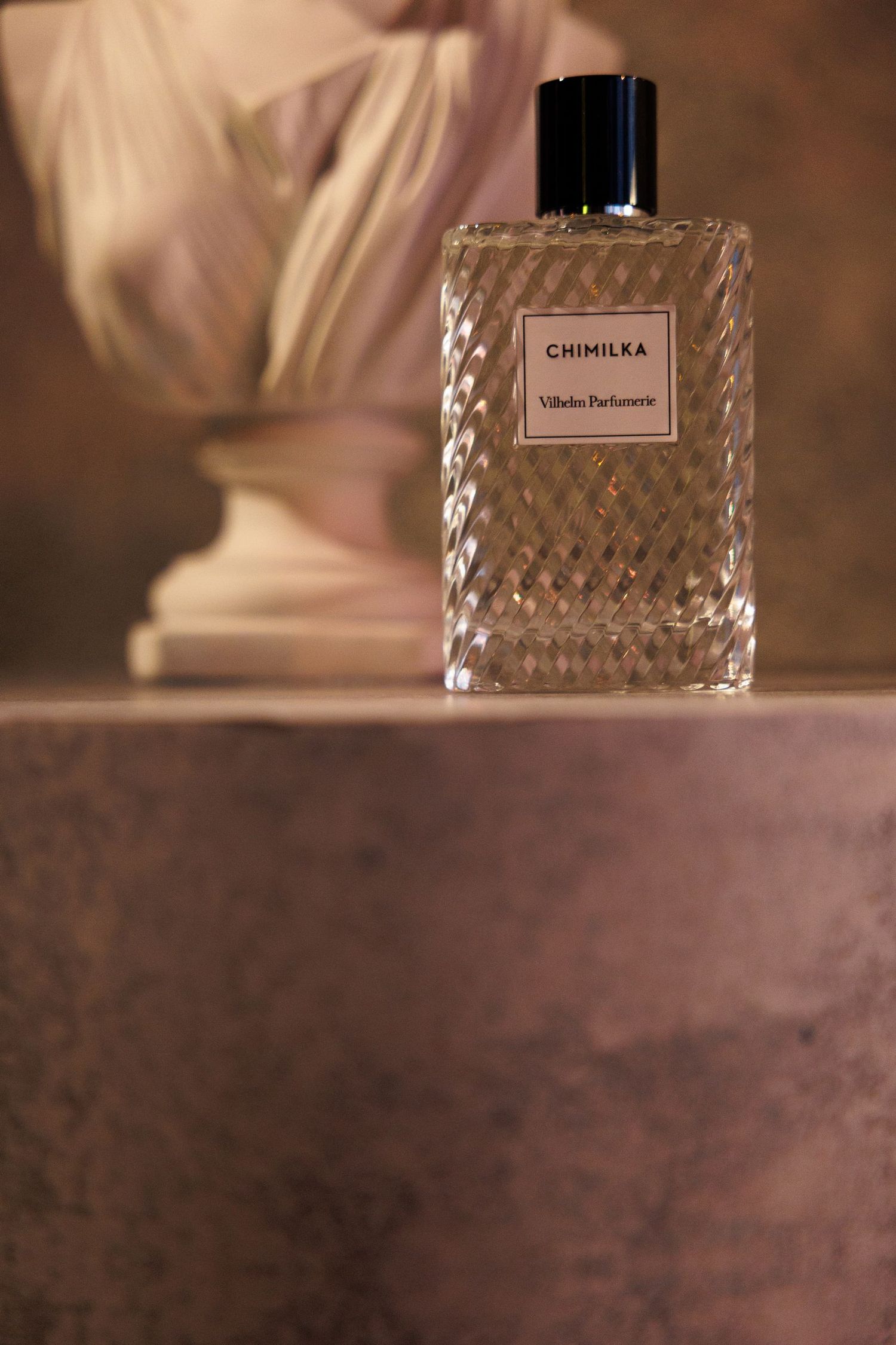 Crystal perfume bottle labeled 'Chinilka' displayed on a dark surface.