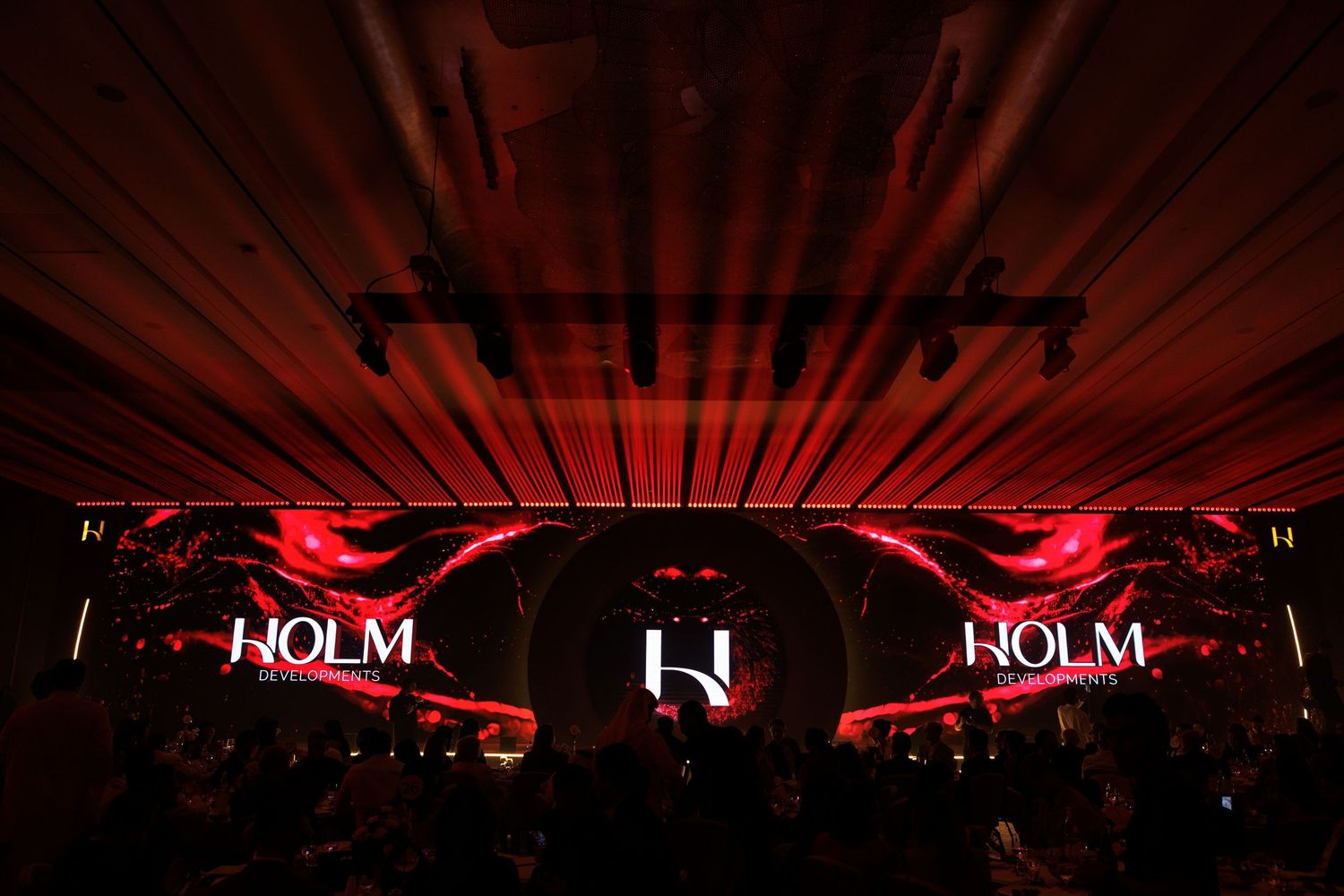 Red stage lighting display creating dramatic rays across a dark venue.