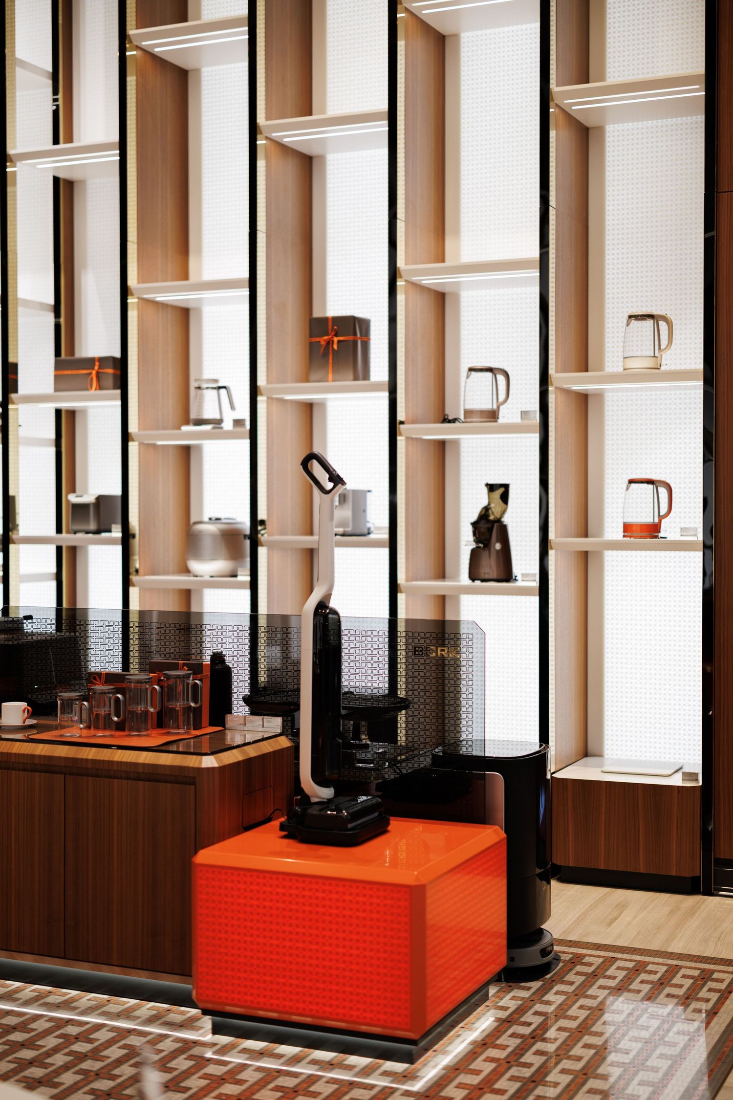Modern kitchen interior with white shelving units and orange accent counter.