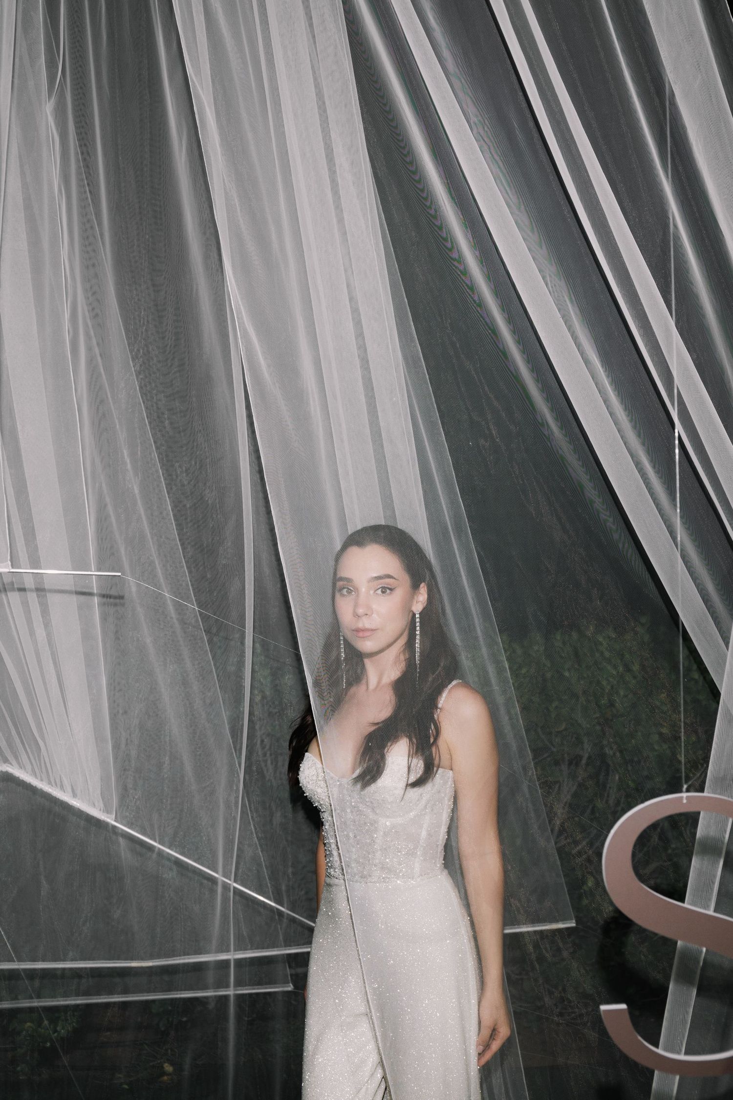 Wedding dress detail shot with flowing white tulle fabric creating an ethereal effect.