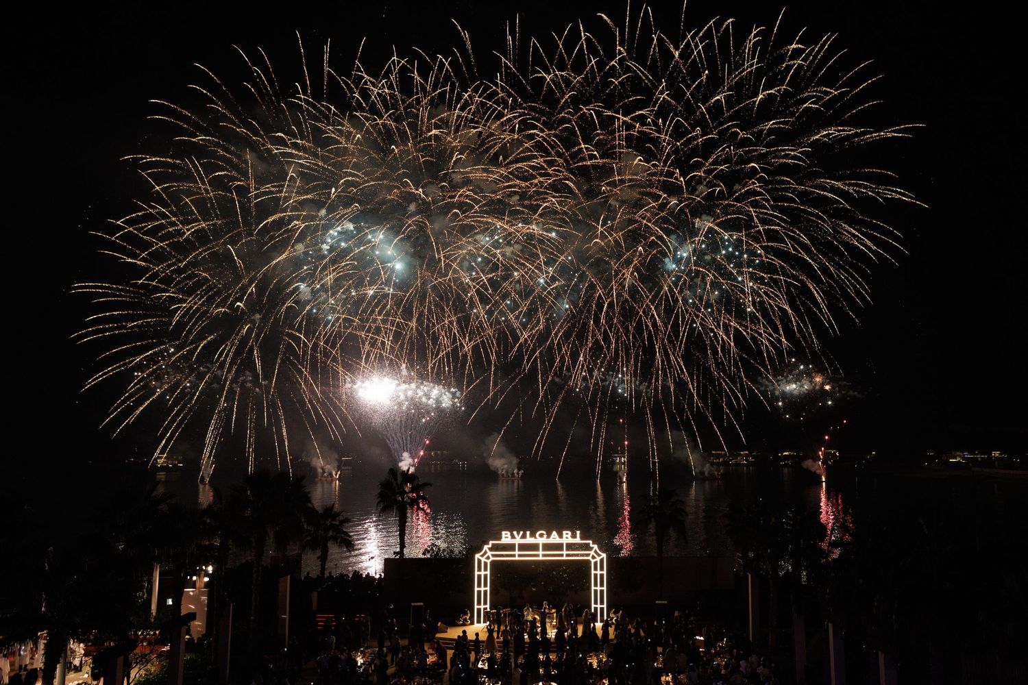 Spectacular fireworks display lighting up the night sky over a dark cityscape.