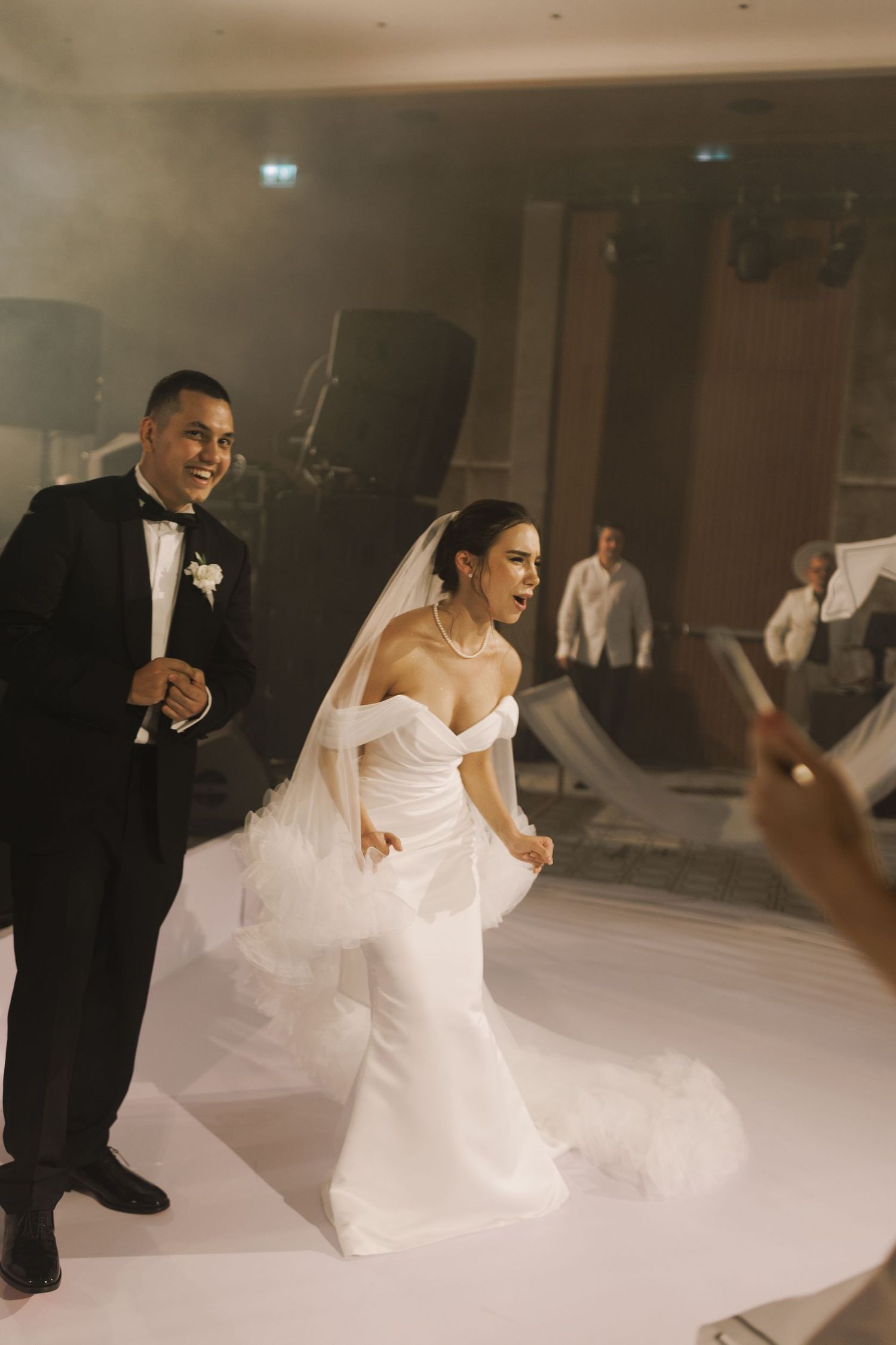 Newlyweds sharing a playful moment on the dance floor during their wedding reception.