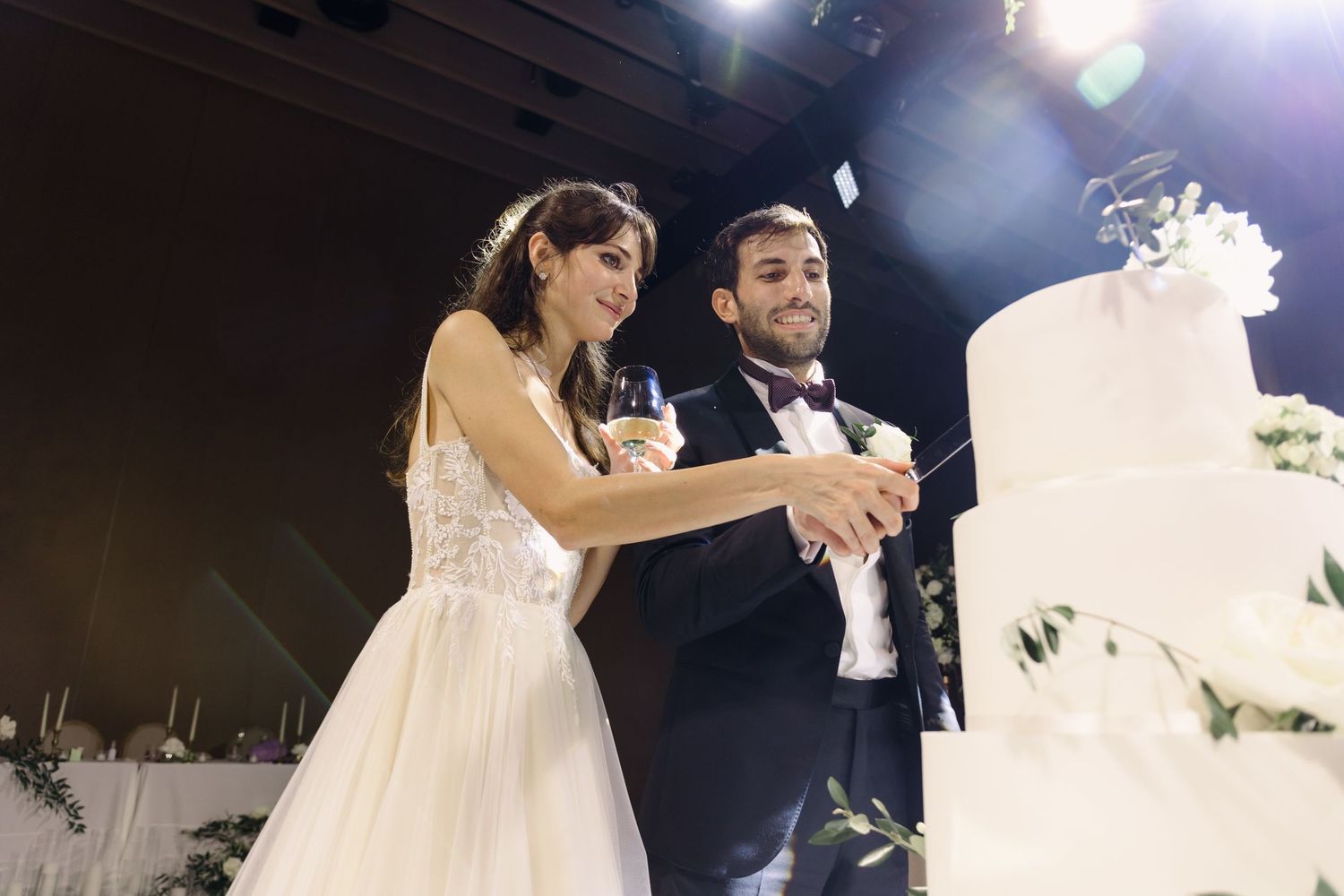 The newlyweds cut their elegant white wedding cake together during the reception.