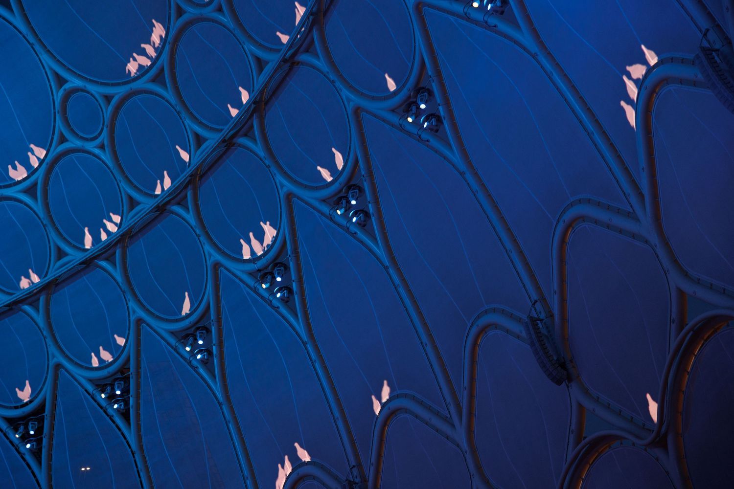Abstract blue lighting design creates geometric patterns against a dark background.