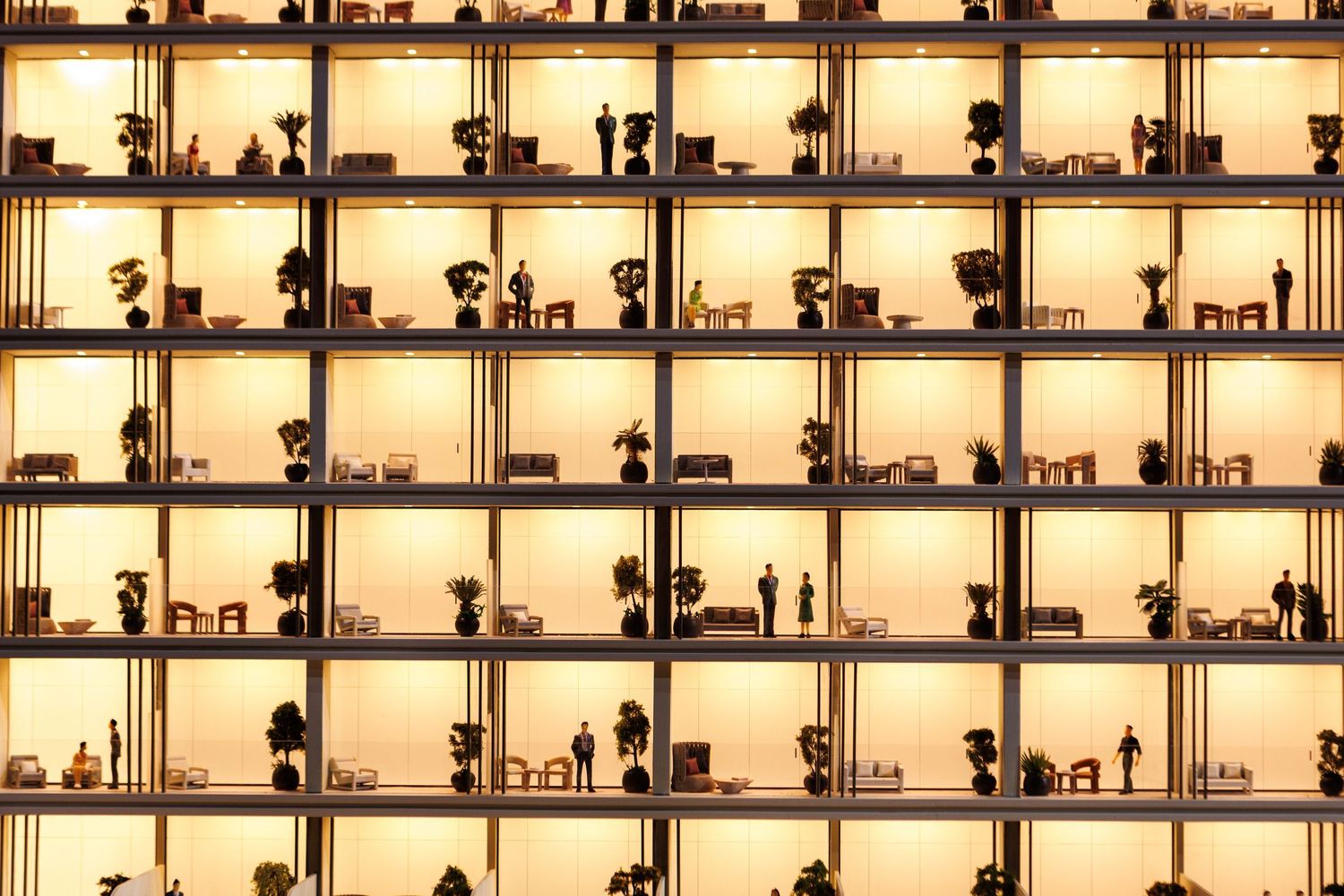 Grid of illuminated windows showing silhouettes of people in various poses and activities.