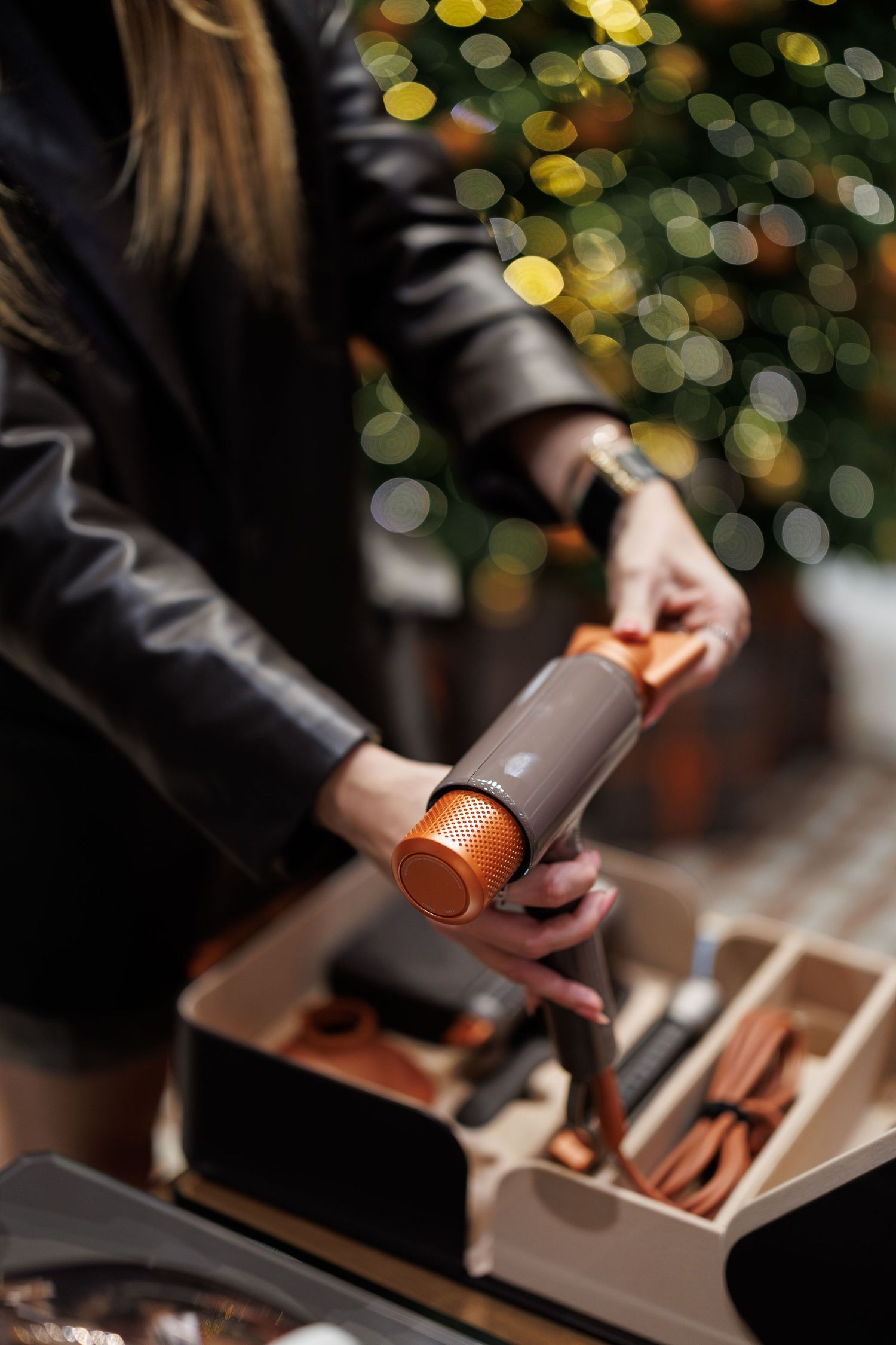 Close-up of hands preparing a cocktail with bokeh lights in the background.