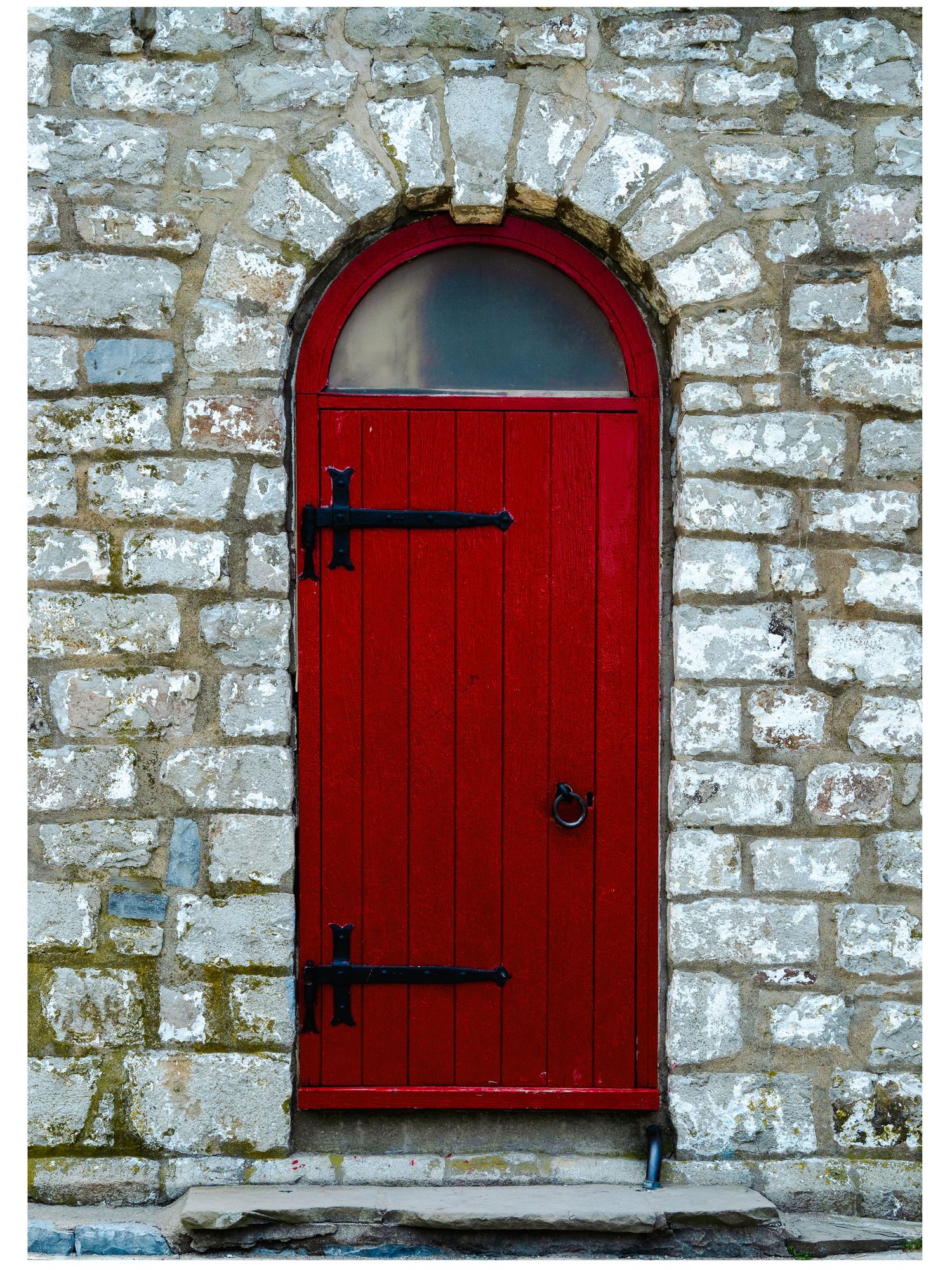 Photo of a red door set in white and grey bricks taken by Liza Fraser at Peachy Moments Photography