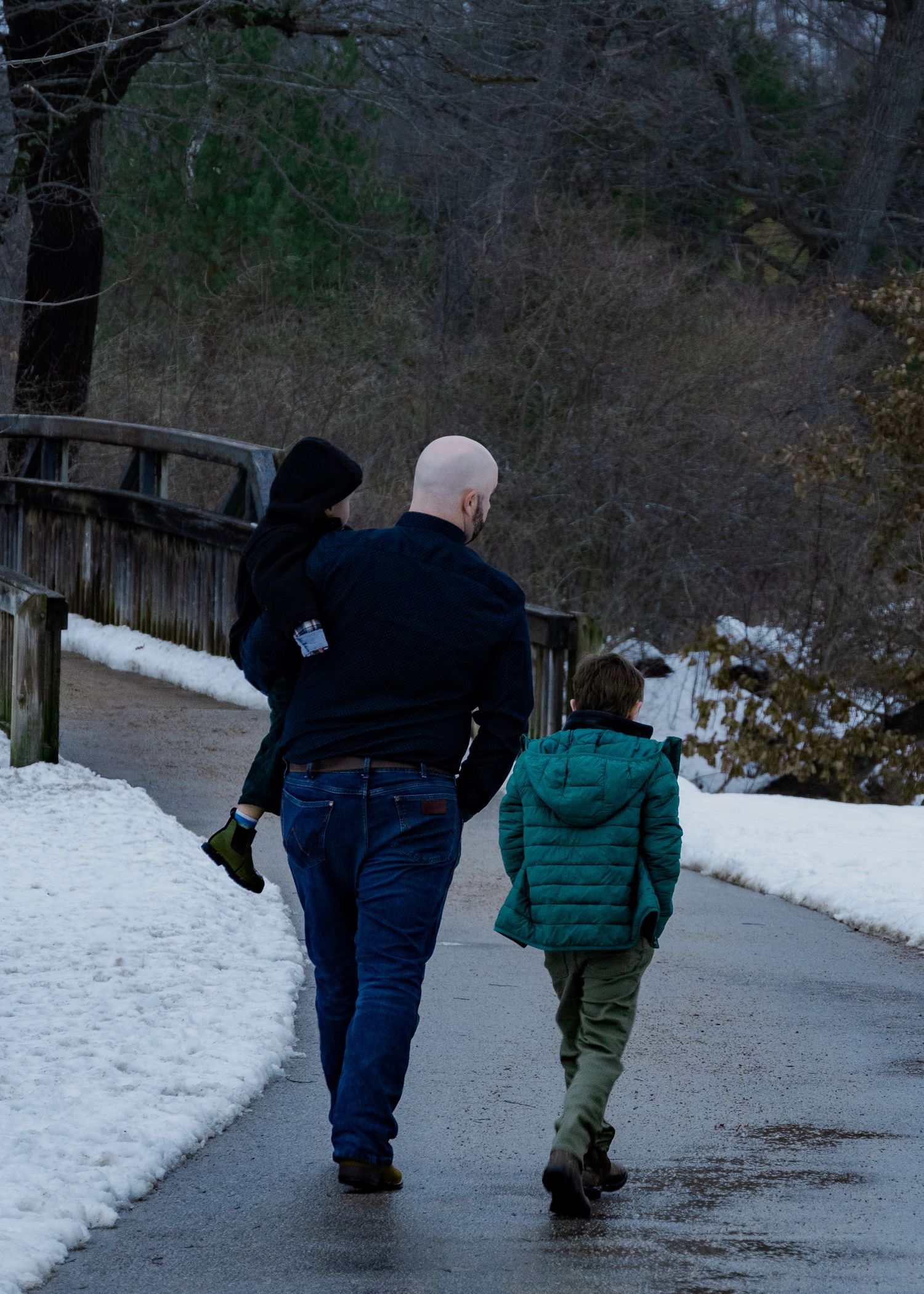 Walking together along a snowy path through the woods on a winter day.