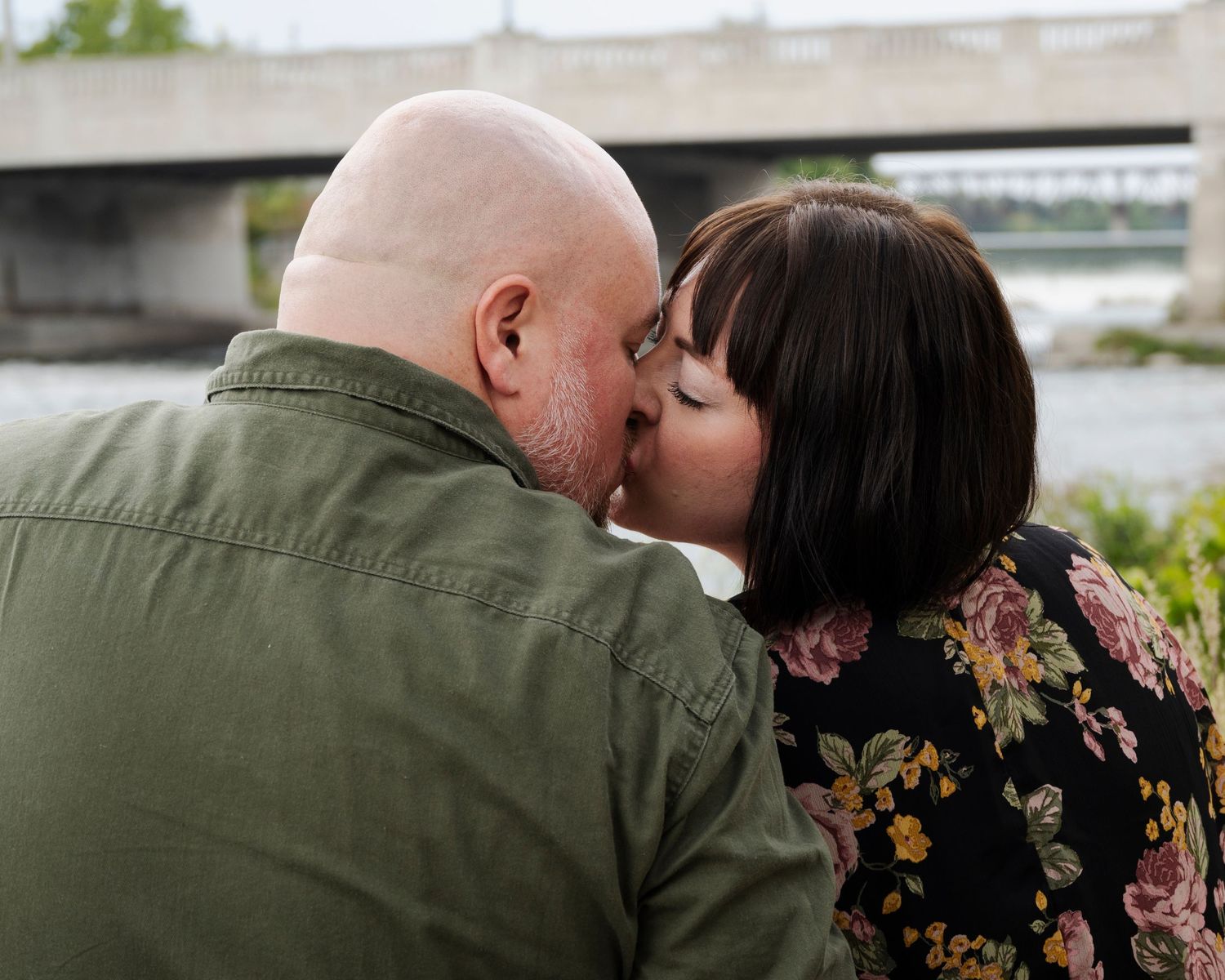 A couple shares loving glances and embraces in a romantic outdoor photoshoot.