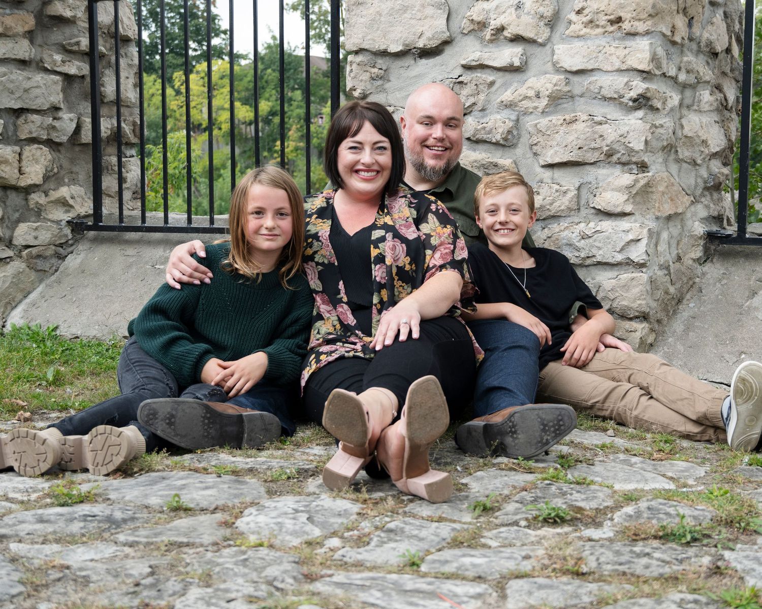 Family members sitting together on stone steps sharing candid moments.