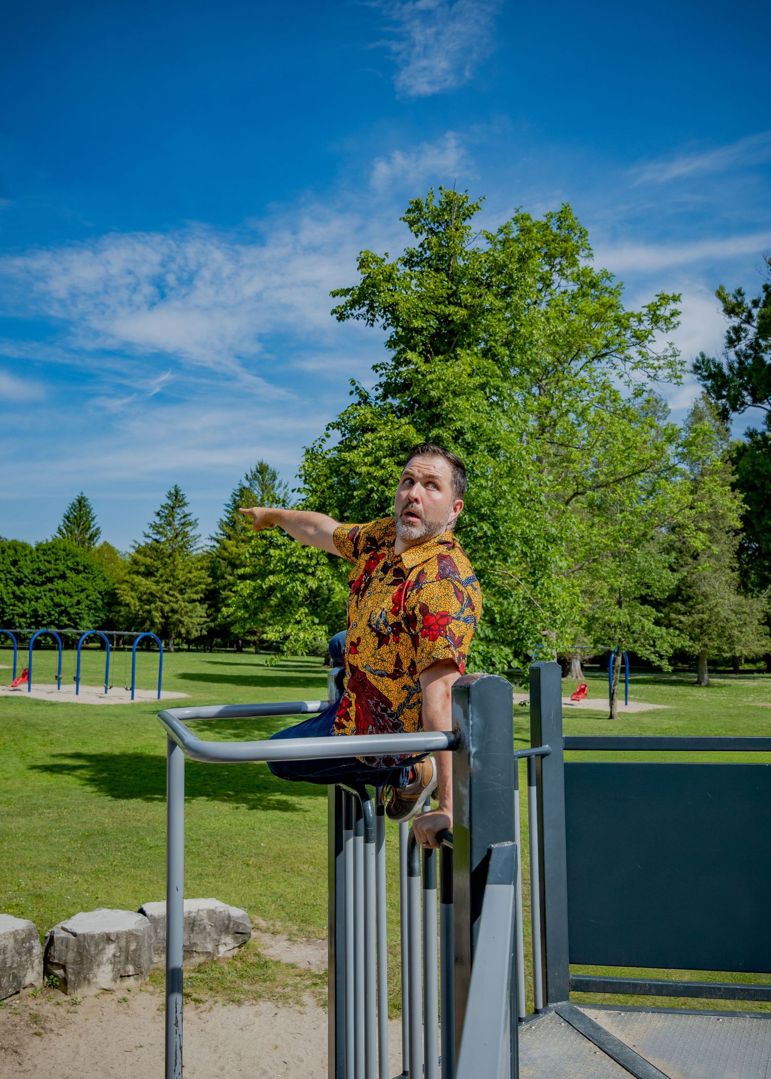 Energetic poses captured on playground equipment against bright blue sky.
