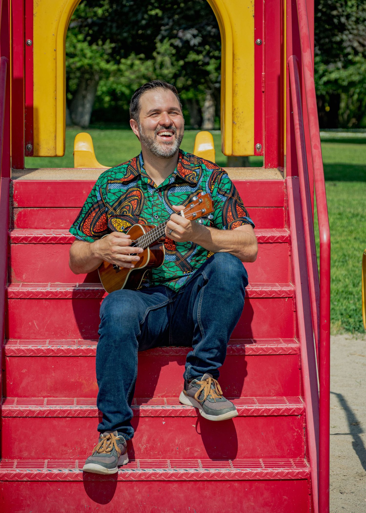 Sequential photos of guitarist performing on bright red and yellow playground stairs.