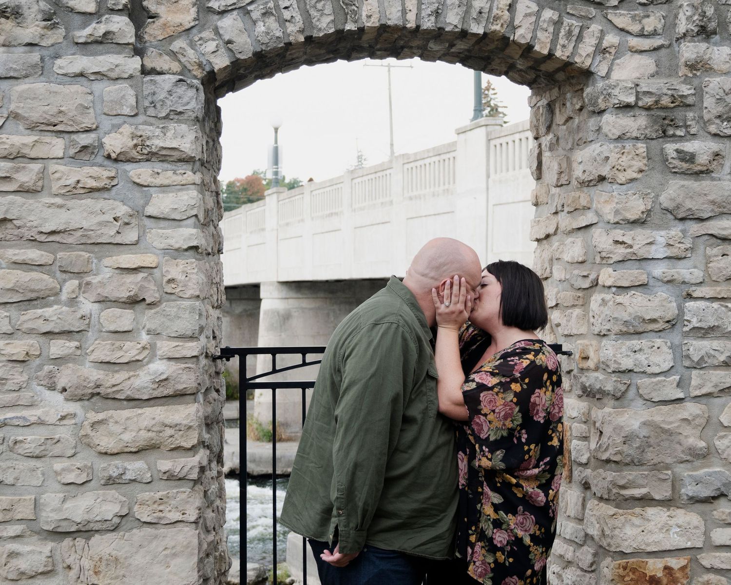 Romantic engagement photos against a rustic stone wall backdrop.