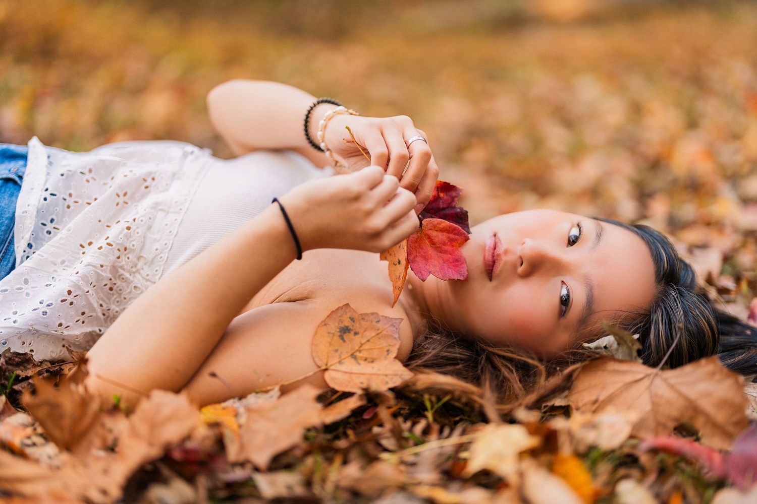 Greensboro, NC Senior Photographer, Reidsville, NC.  Ryan Harden.  stunning portrait of girl laying in bed of fall leaves.